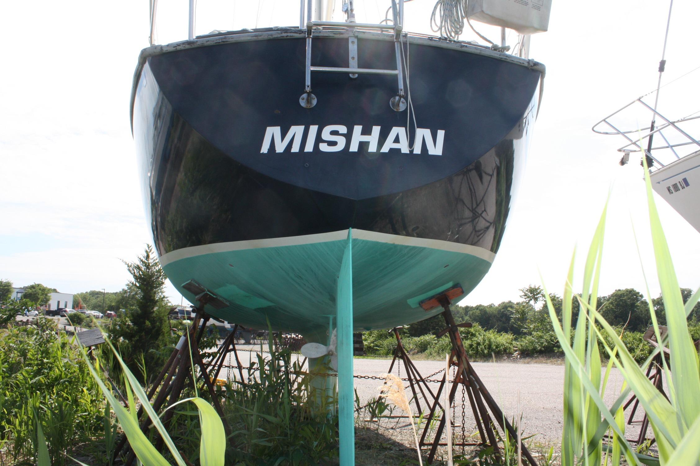 1981 S2 9.2A sailboat named "Mishan" on stands, surrounded by greenery.