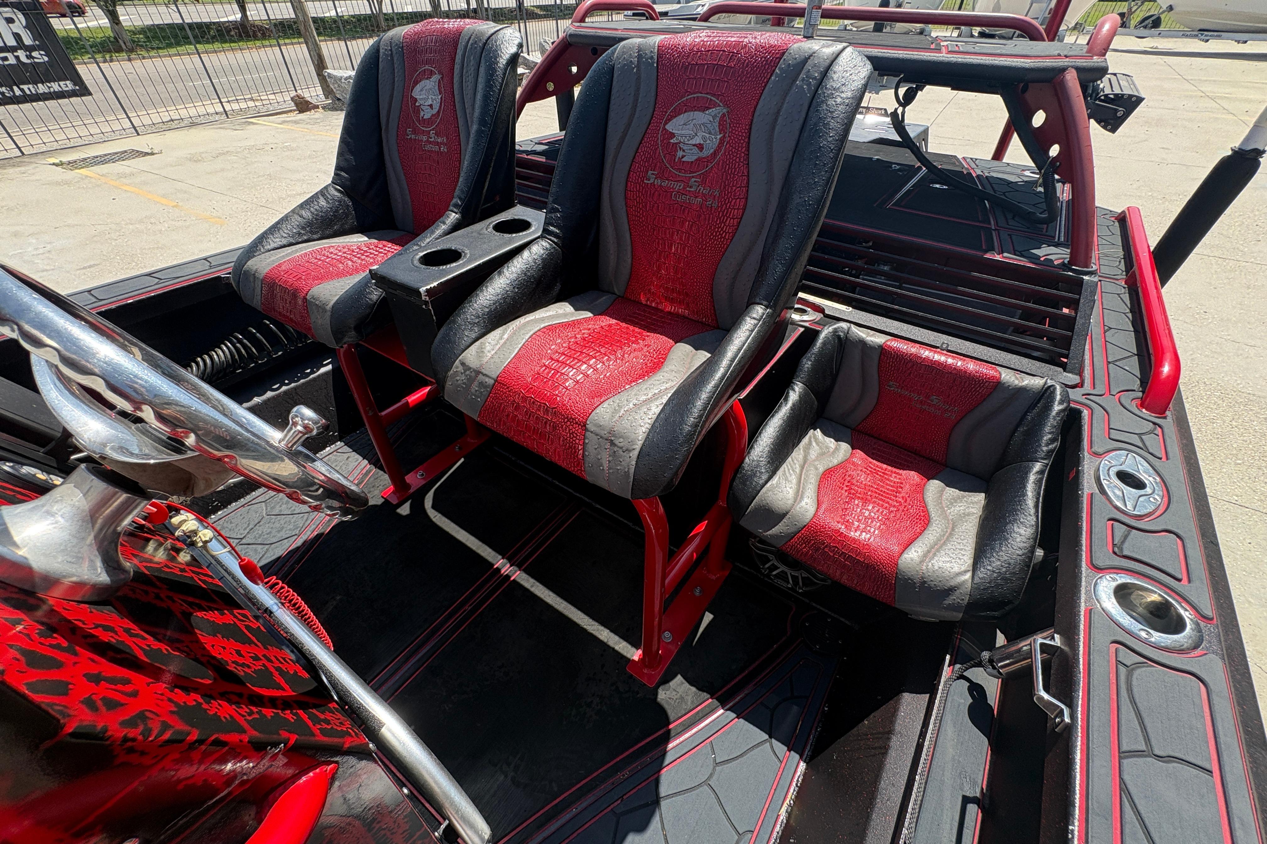 Custom 2018 Swamp Shark 24' boat interior with red and black seats and steering wheel.