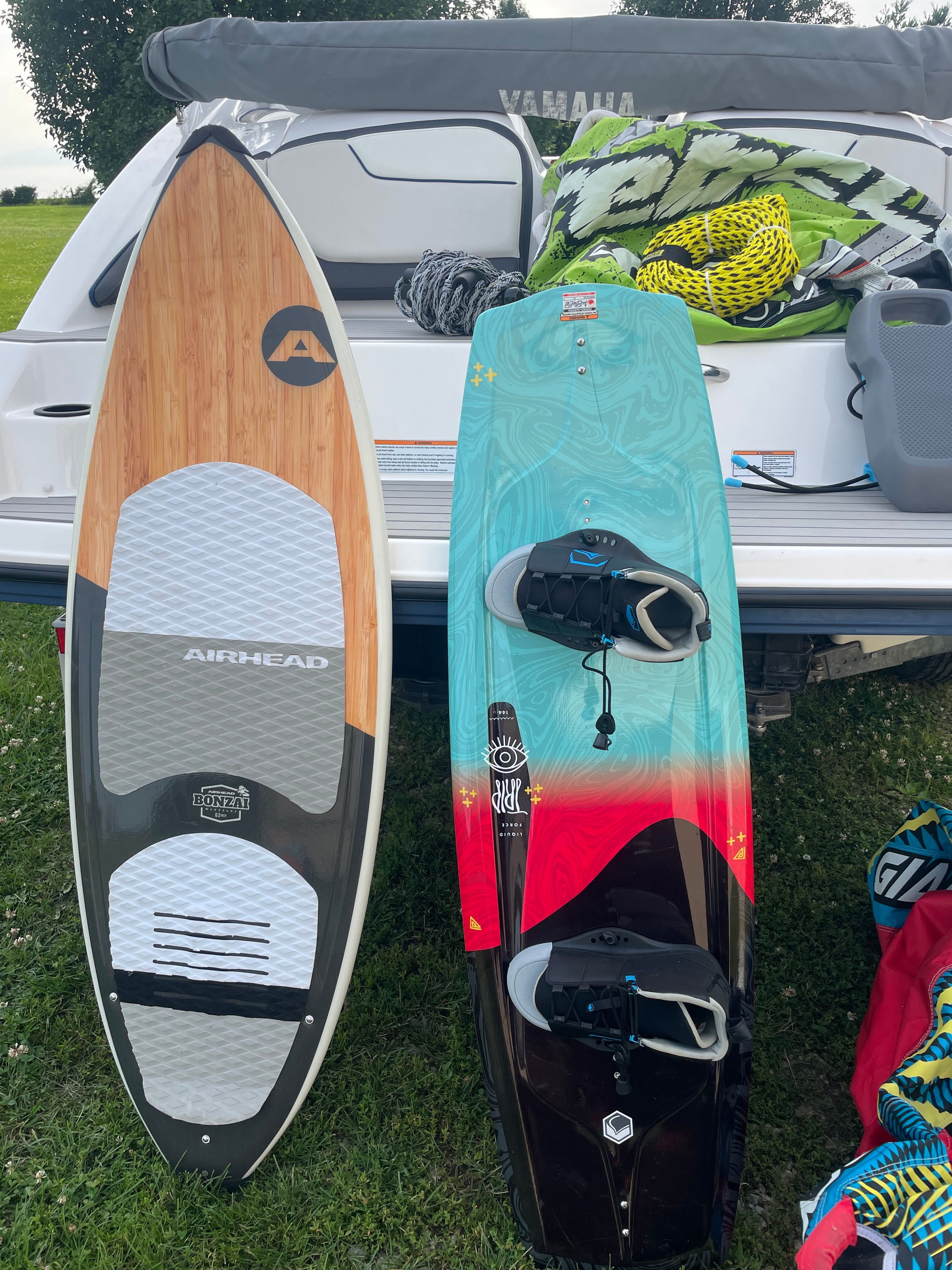 A 2019 Yamaha SX210 boat with two wakeboards and life jackets on the grass.