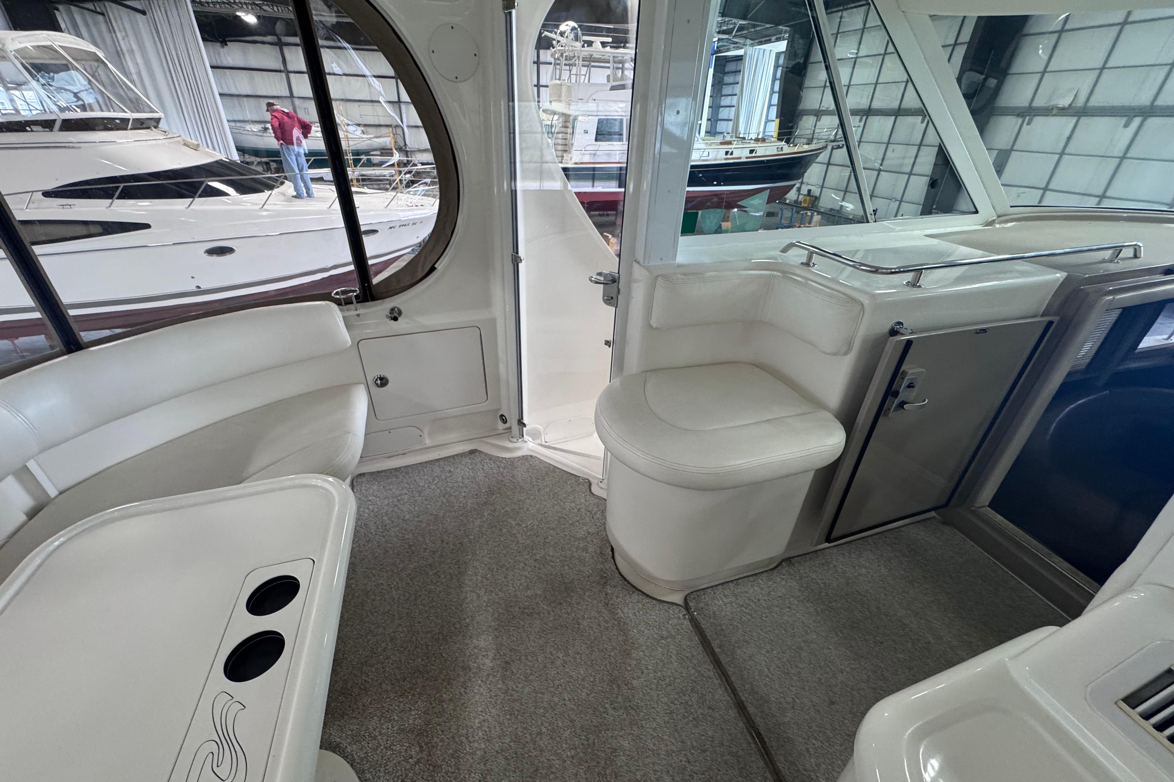 2004 Sea Ray 390 Motor Yacht interior with white seating and table in a marina setting.
