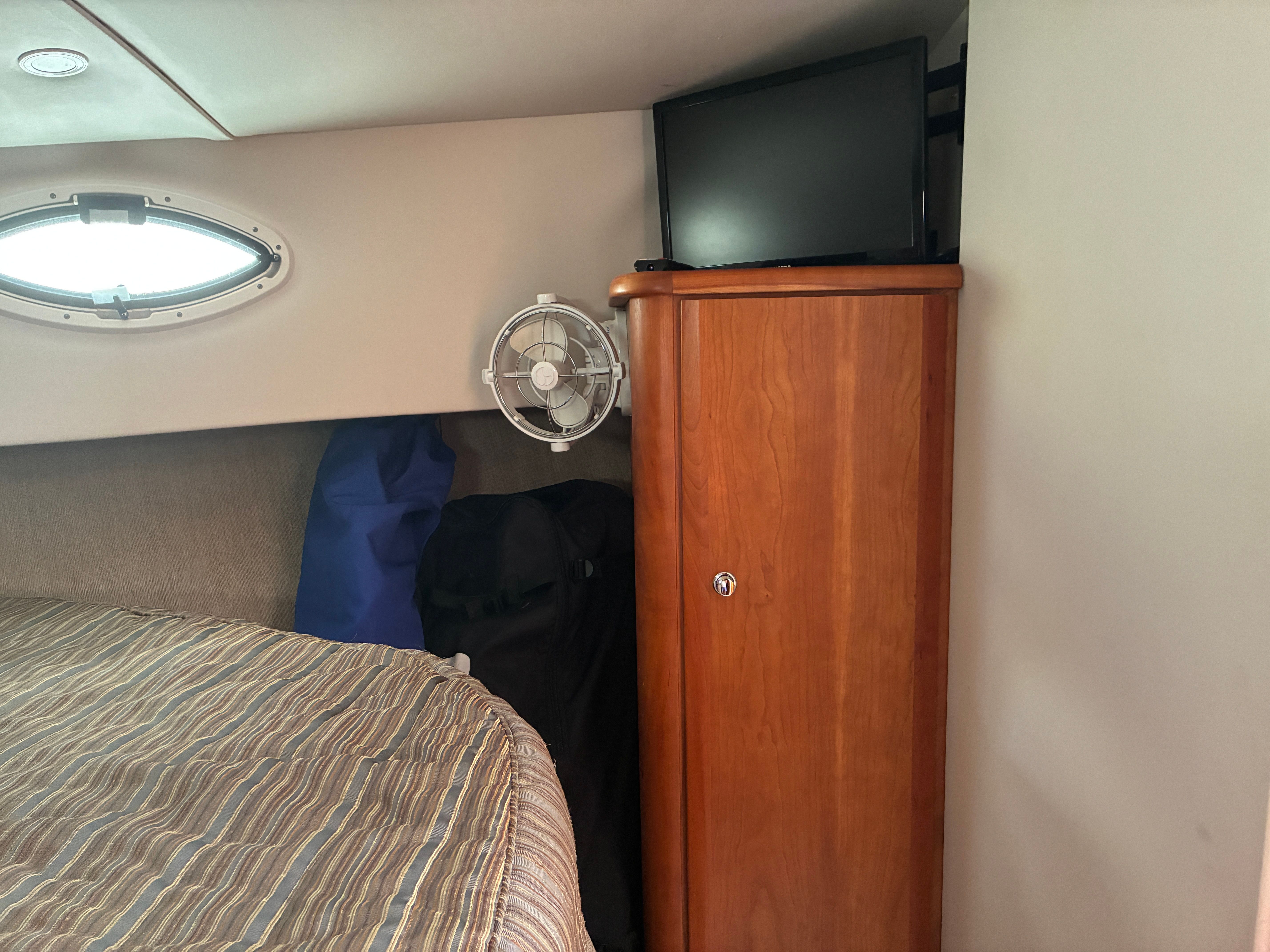 Interior of a 2001 Silverton 392 Motor Yacht with bed, cabinet, and TV.