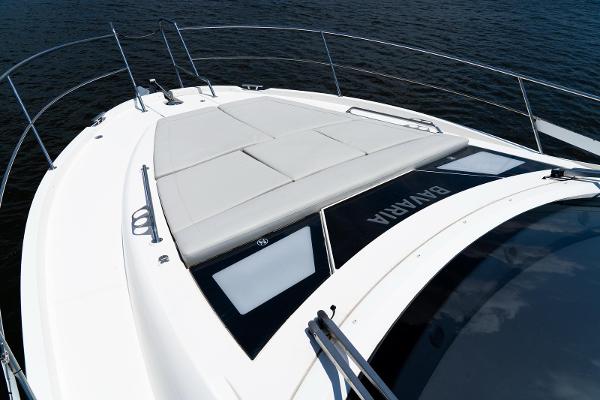 2022 Bavaria SR41 yacht deck with sunbathing area, sleek design, and railing on calm water.