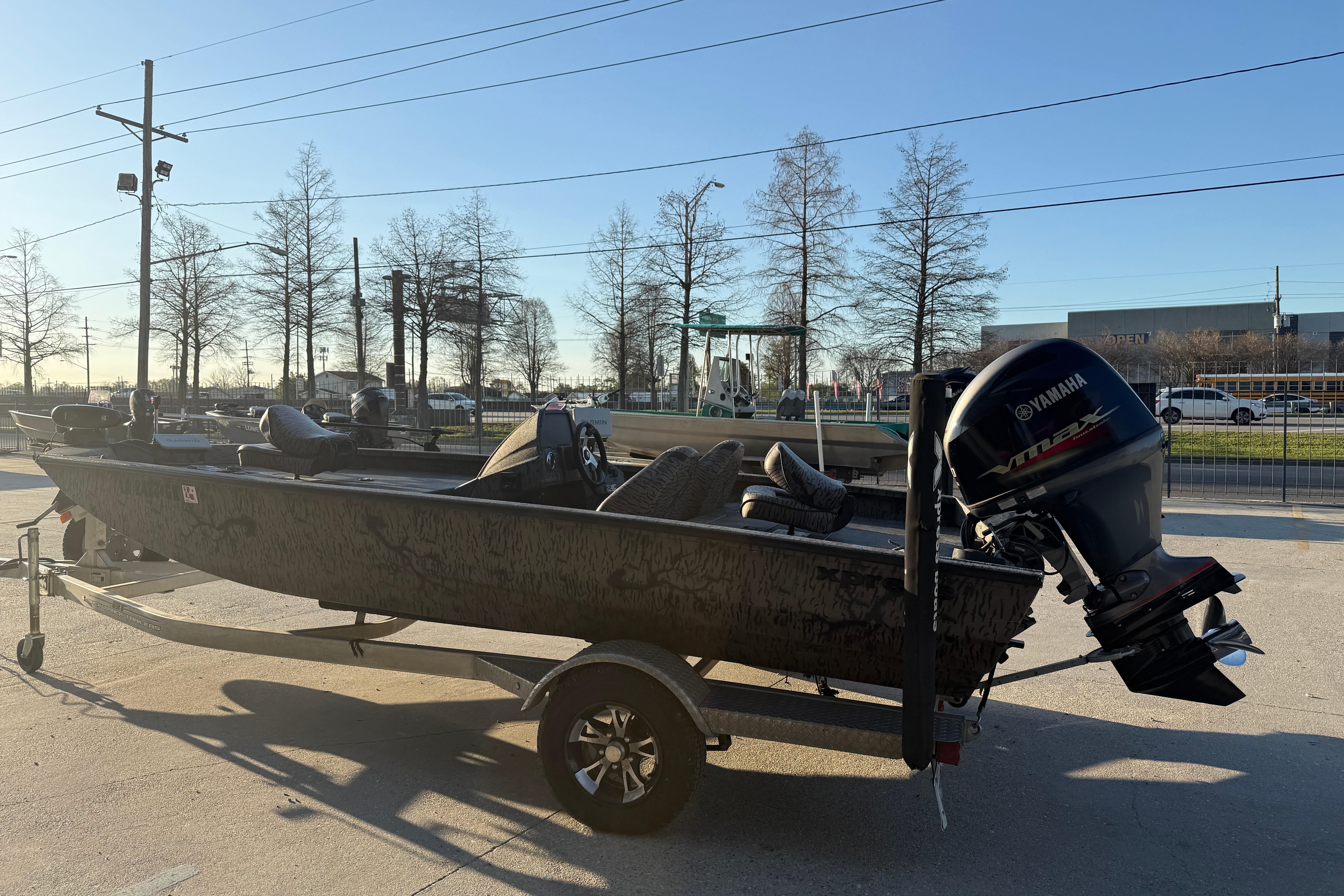 2019 Xpress XP7 boat with Yamaha engine on trailer, parked outdoors.
