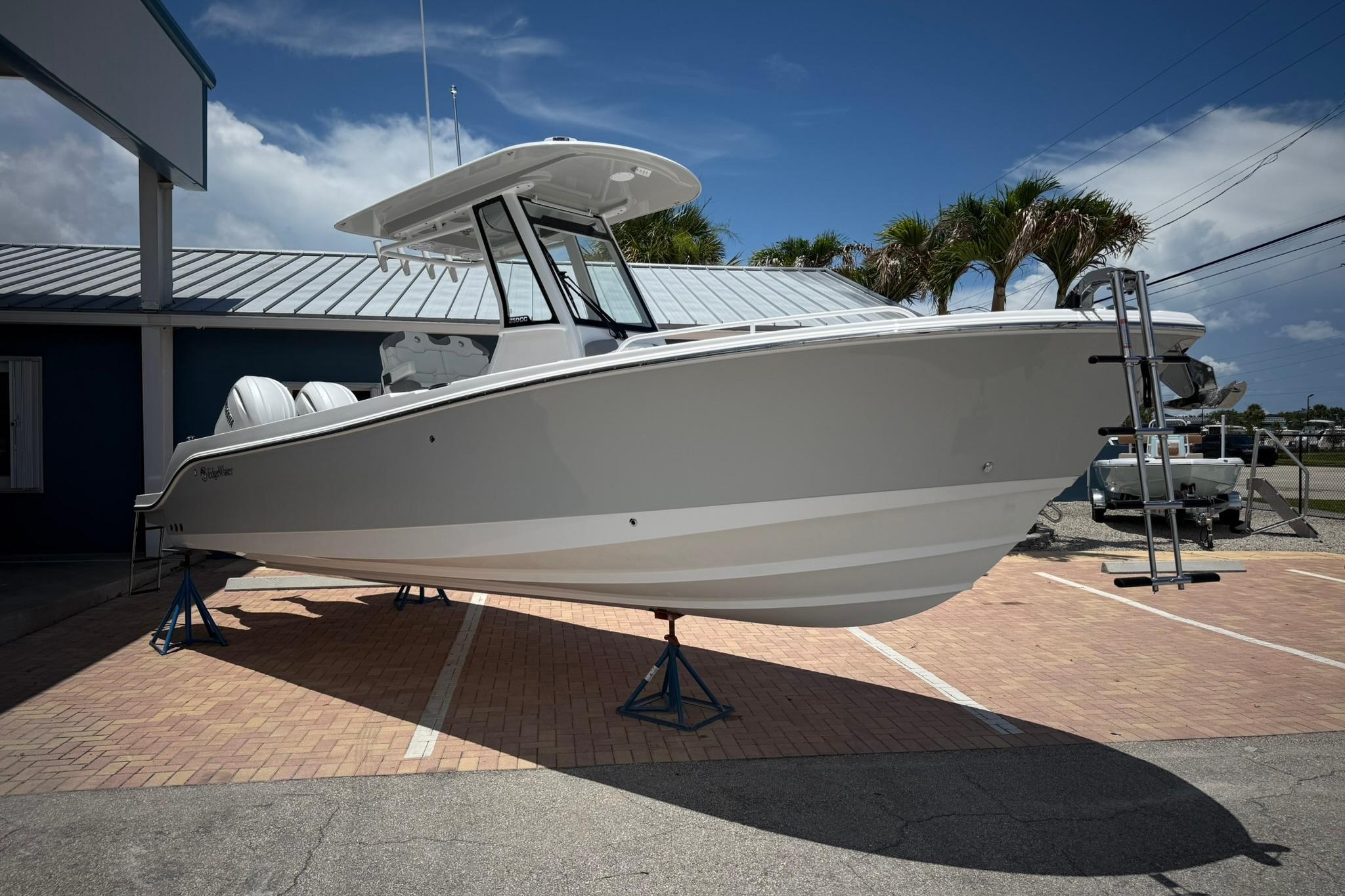 2026 Edgewater 250CC boat displayed outdoors on stands, under a clear blue sky.