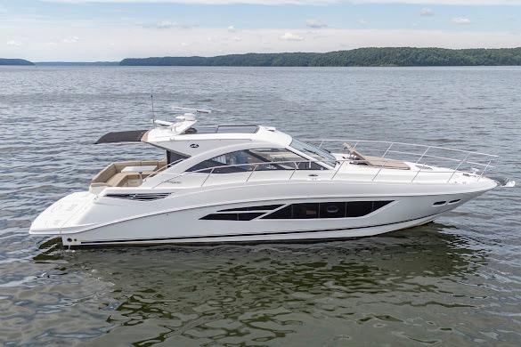 2016 Sea Ray Sundancer 510 yacht cruising on a calm lake under a clear sky.
