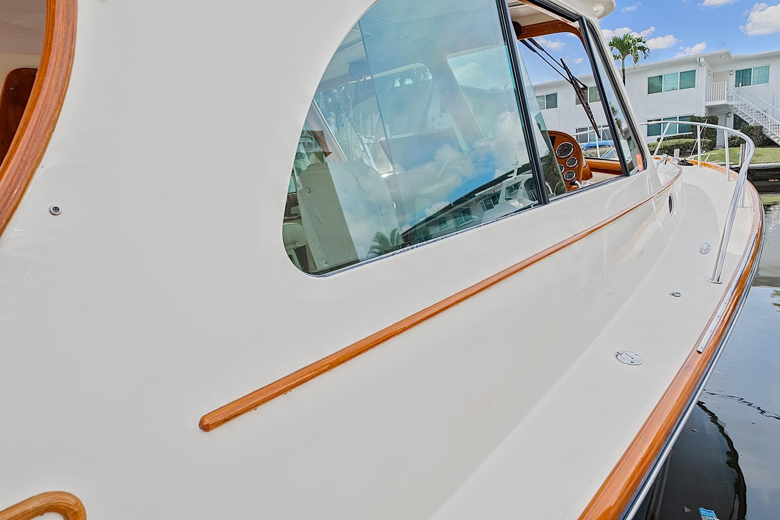 2018 Hinckley Picnic Boat 37 MKIII, elegant design with polished wood accents, docked by waterfront homes.