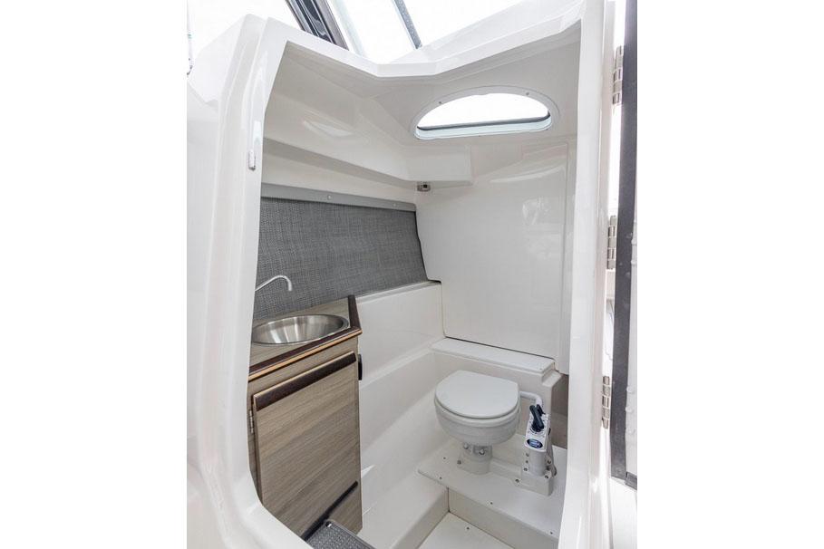 Manufacturer Provided Image: 2025 Solara S-250 DC boat interior with compact bathroom, featuring a toilet and sink.