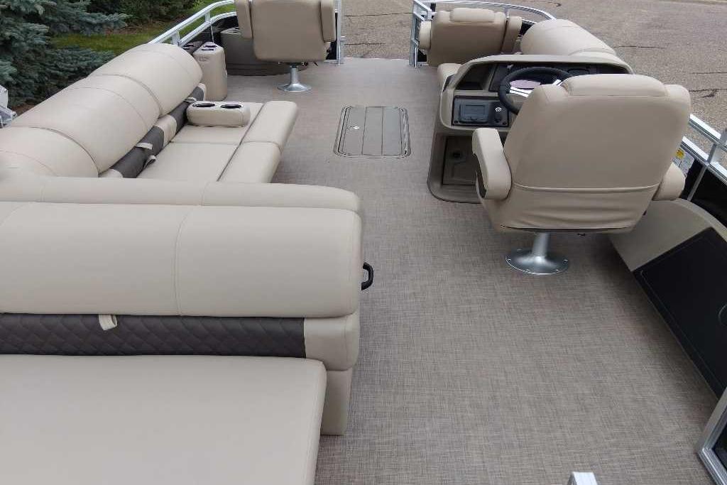 2025 Sun Tracker Sportfish 24 XP3 pontoon boat interior with beige seating and helm.