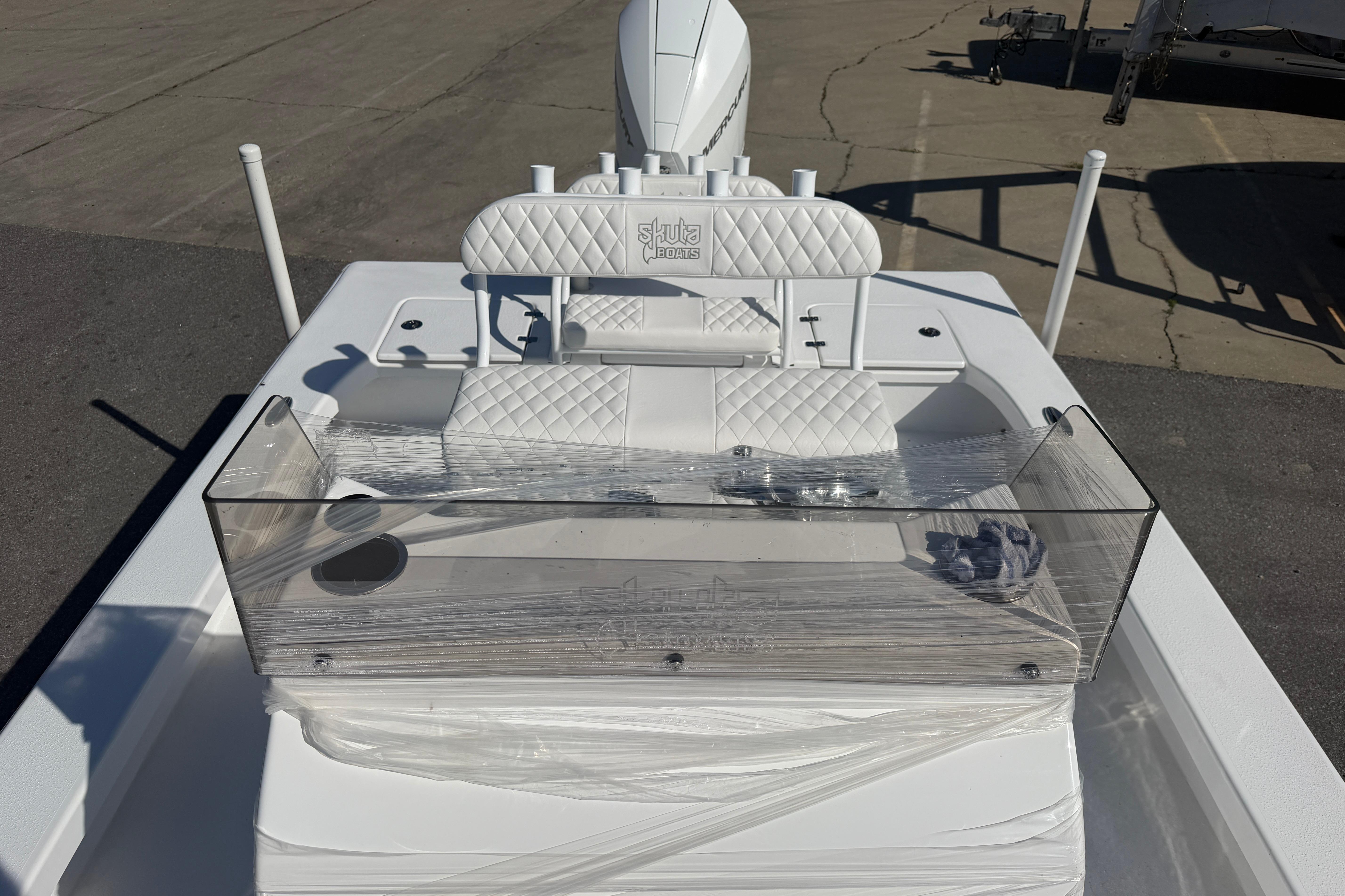 2026 Skuta 24 Cat boat with white quilted seating and clear windshield.