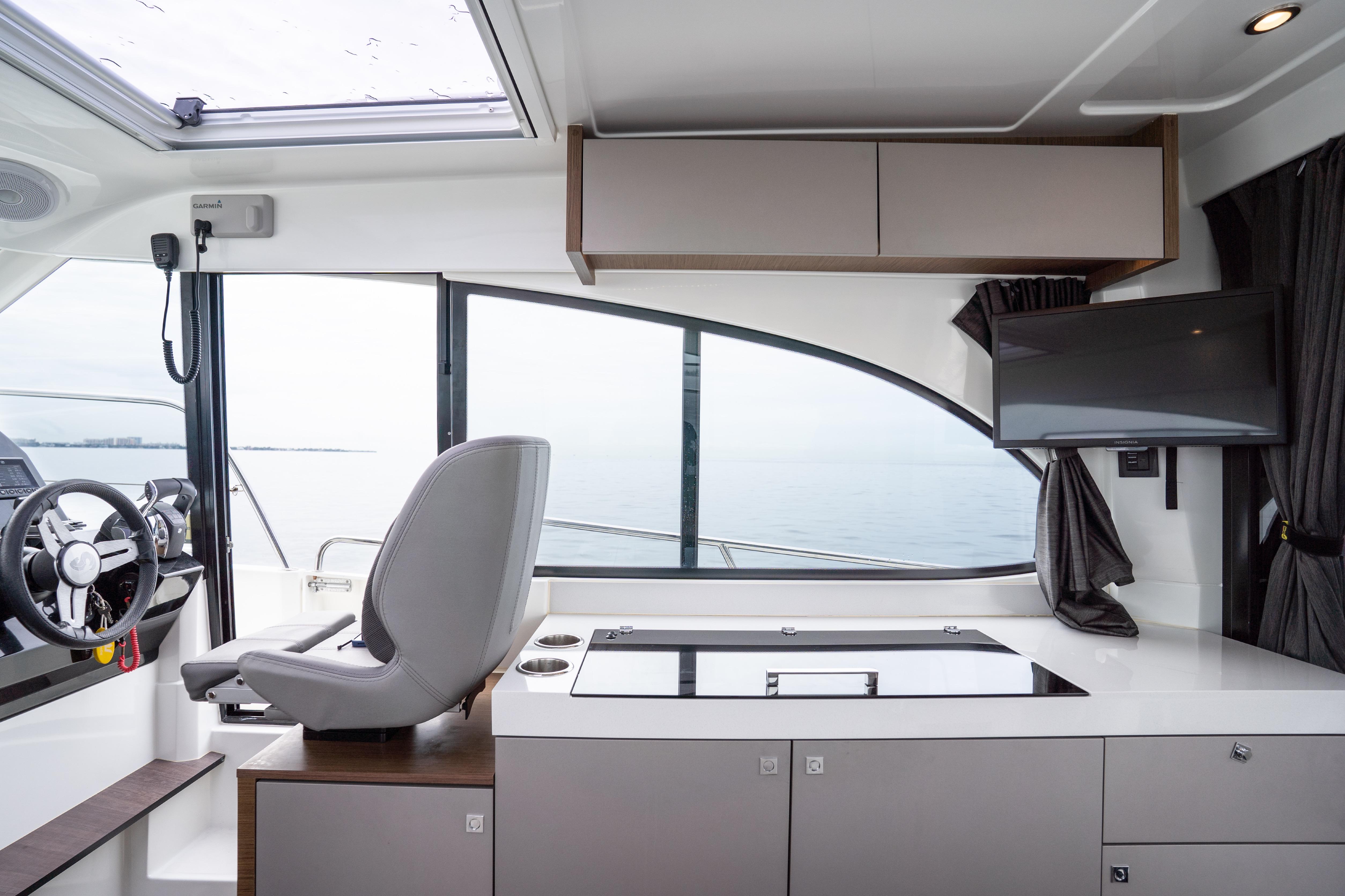 Interior of 2023 Beneteau Antares 11, featuring helm, seating, and modern amenities.