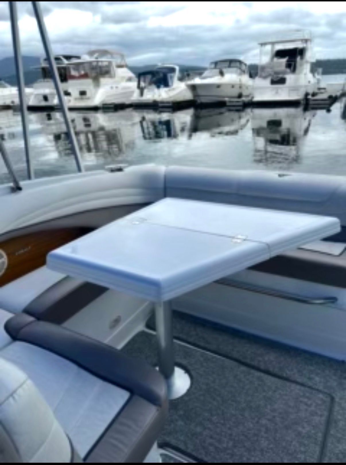 A 2001 Cobalt 293 with a table in the cockpit area, surrounded by other boats in the marina.