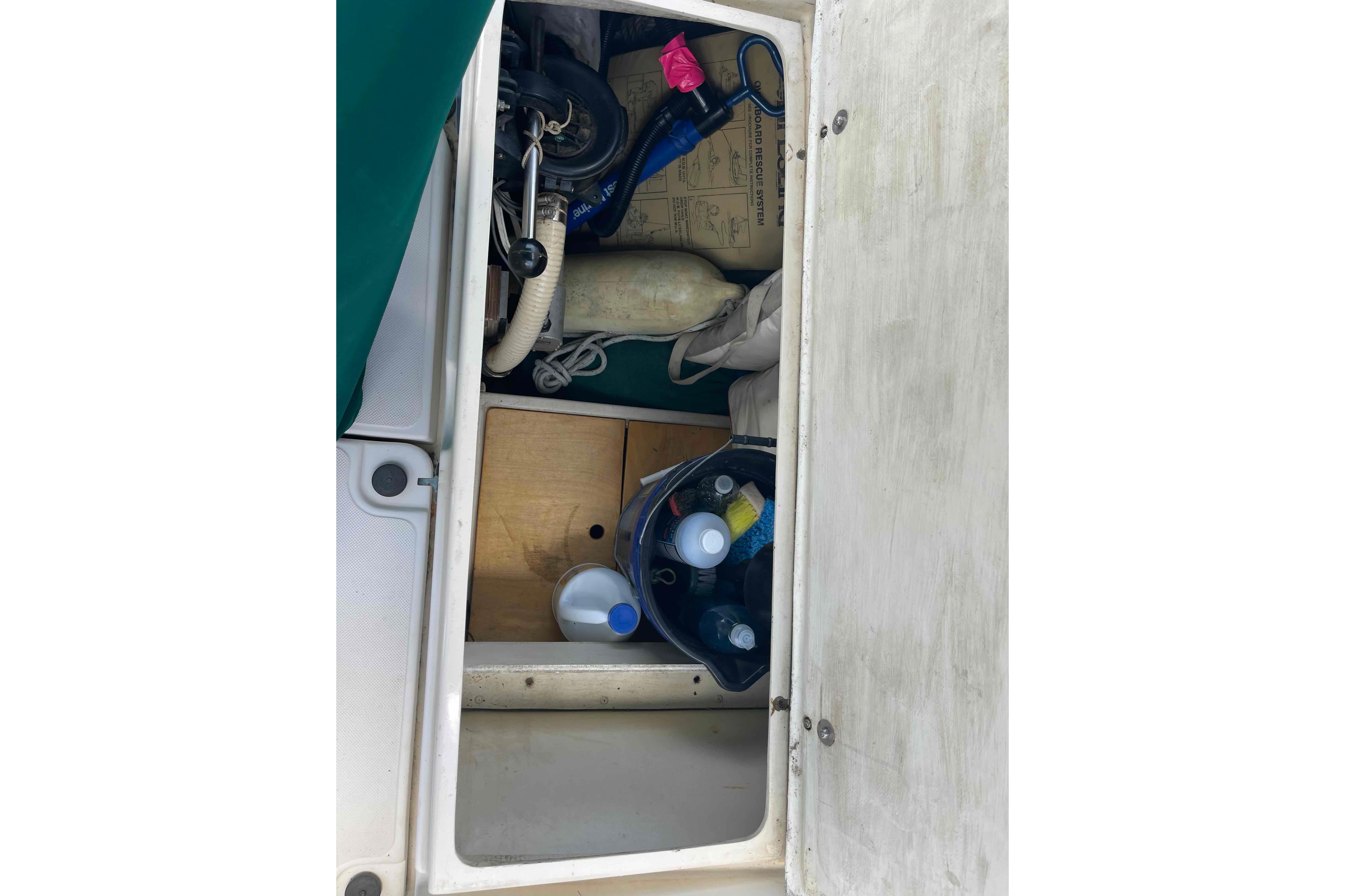 Storage compartment of a 1987 Pacific Seacraft 34 sailboat with various equipment and supplies.