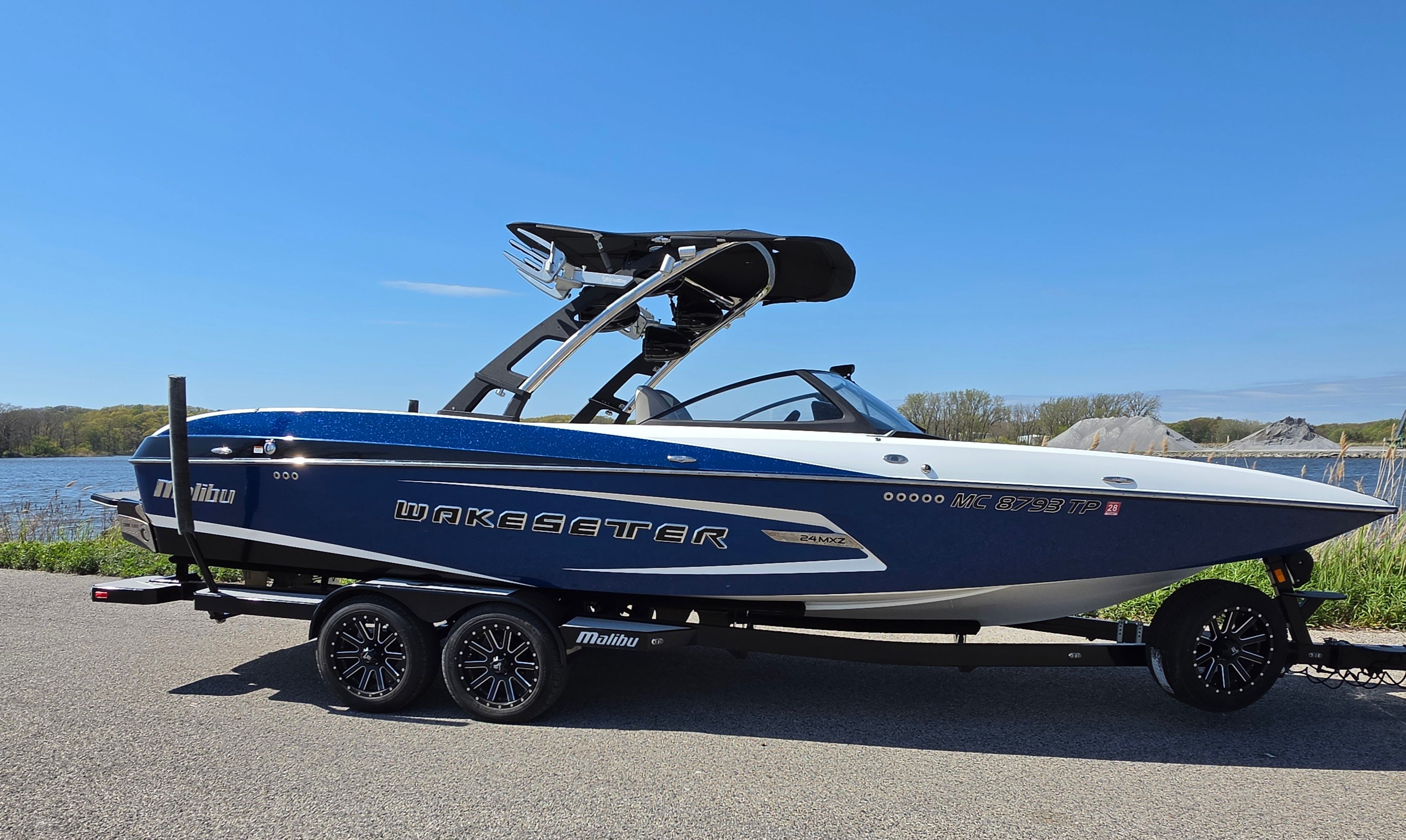 2014 Malibu Wakesetter 24 MXZ boat by the lakeside.