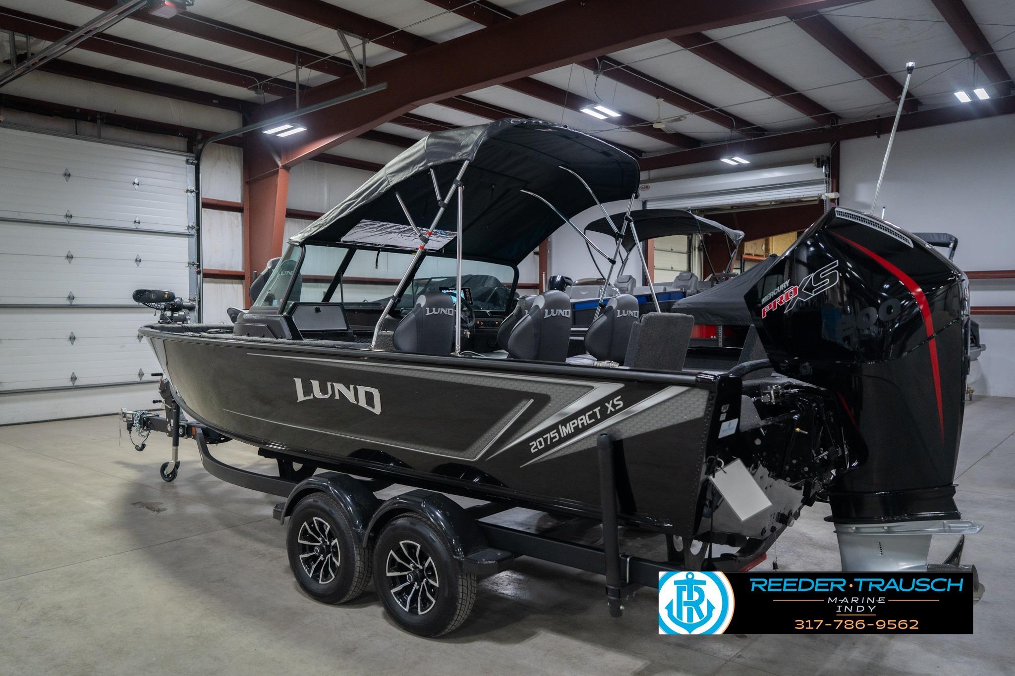 2026 Lund 2075 Impact XS boat in showroom, featuring sleek design and modern features.