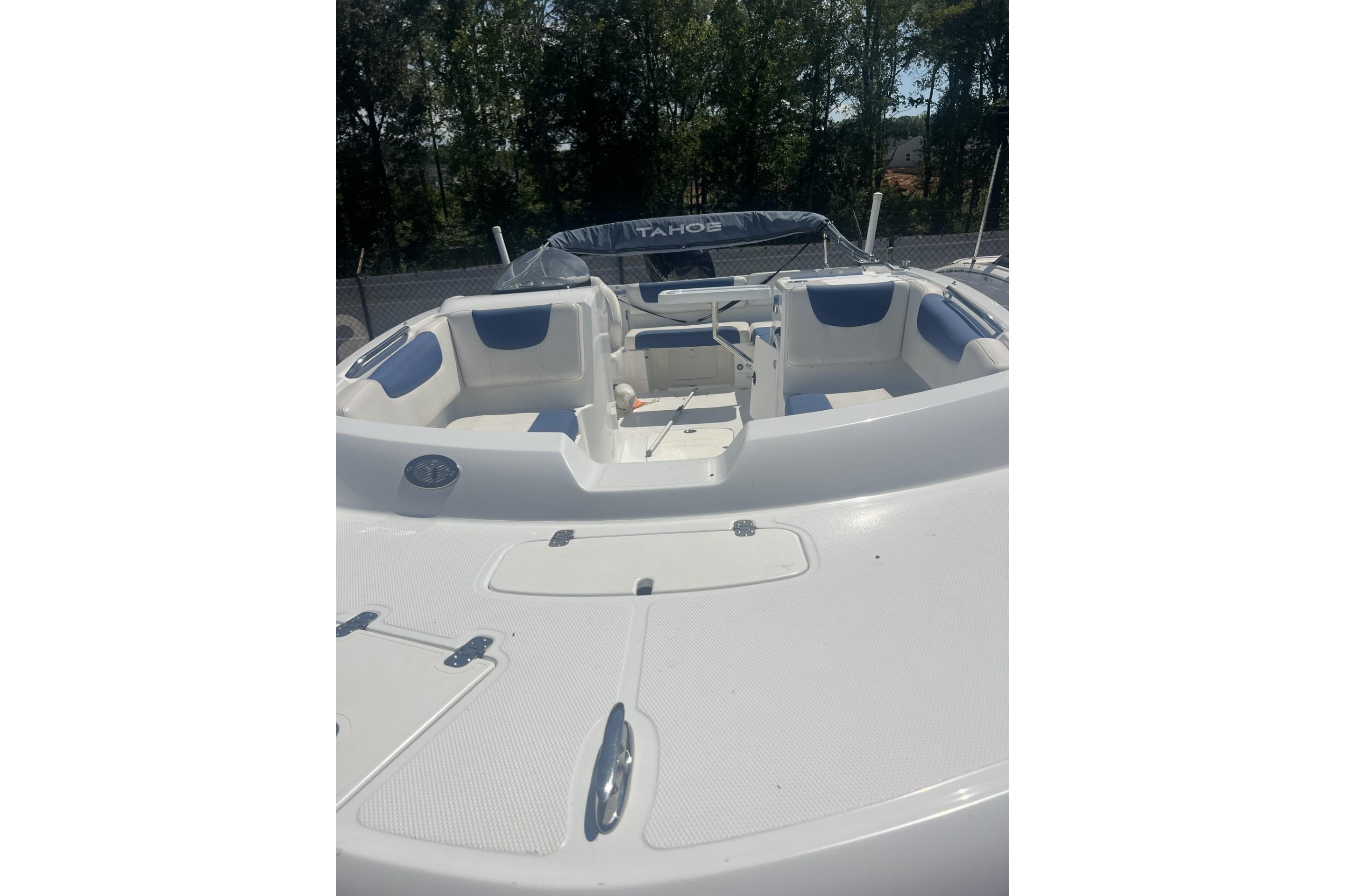 2017 Tahoe 2150 boat interior with white and blue seating, surrounded by trees.