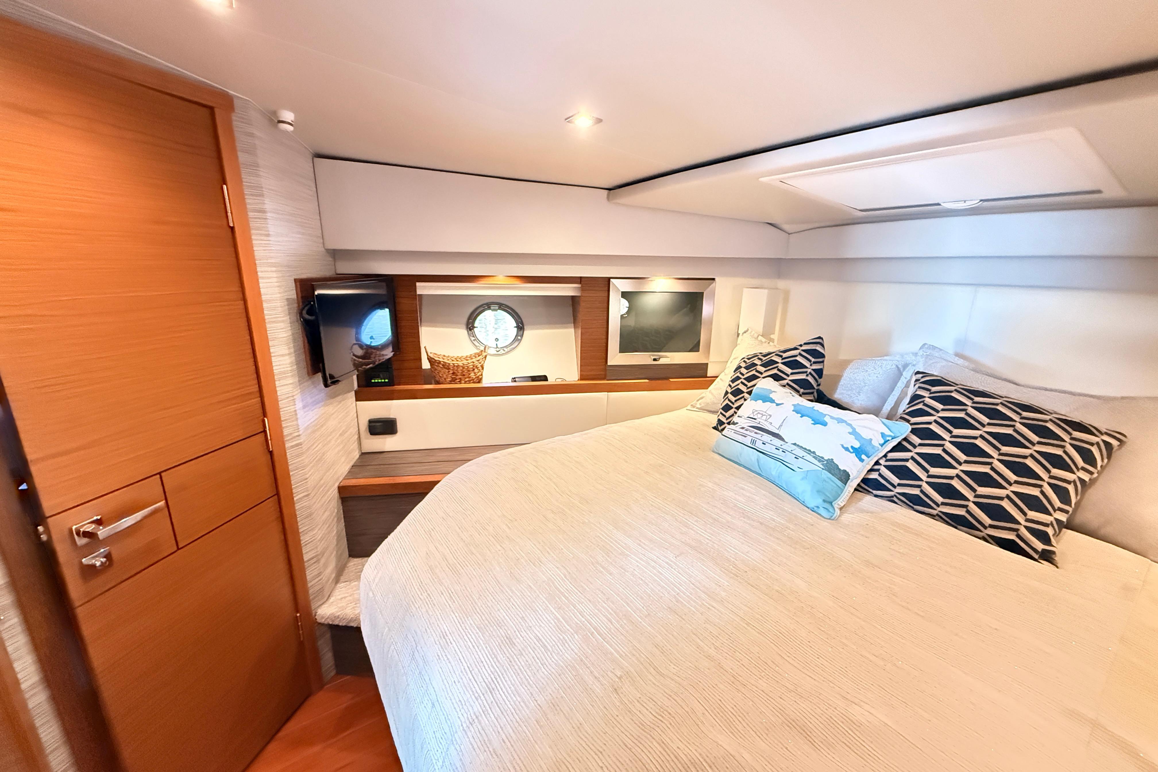 Luxurious cabin interior of 2020 Tiara Yachts C44 Coupe with cozy bedding and modern decor.