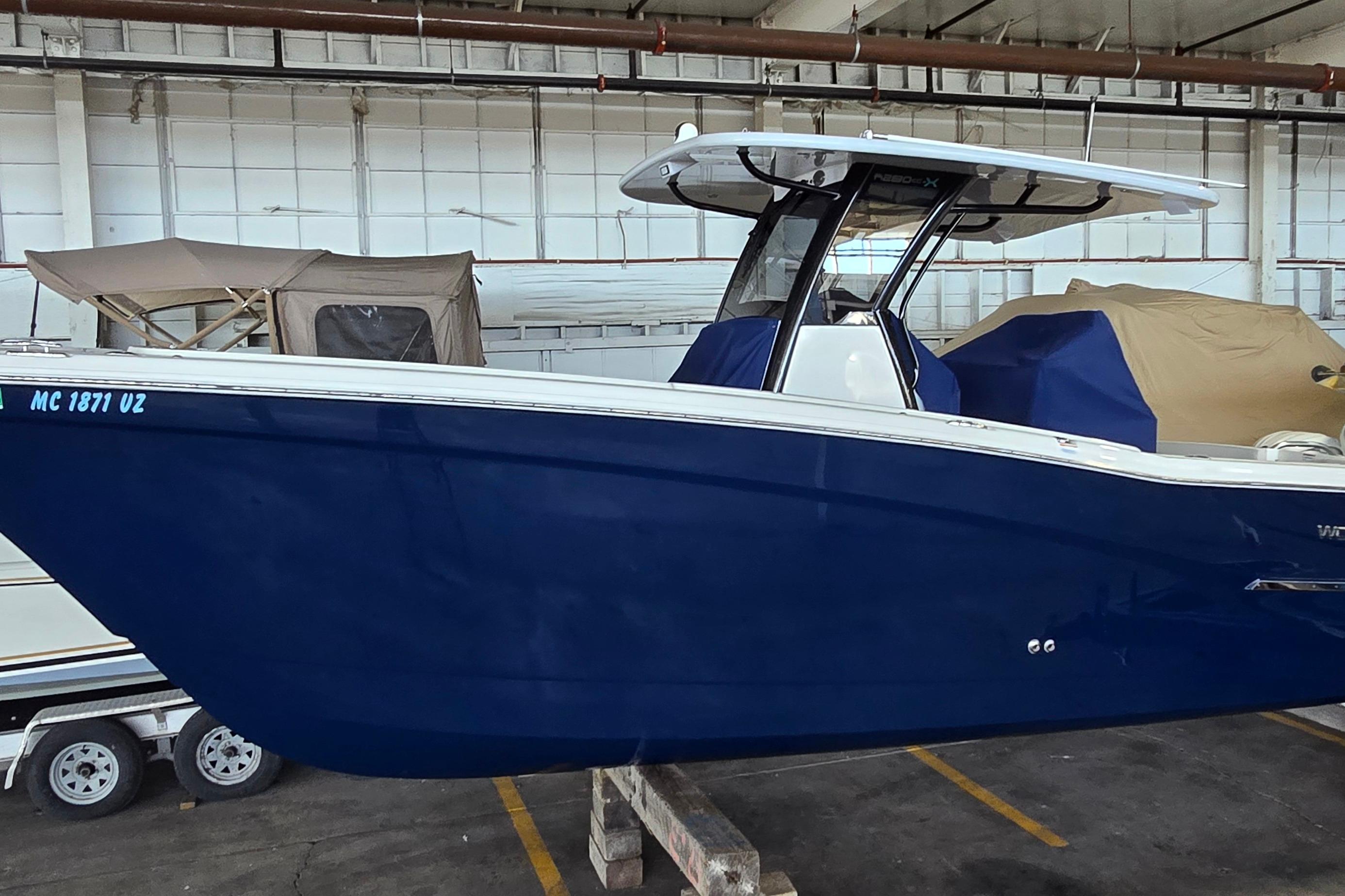 2024 WorldCat 280 CC-X boat in storage, featuring a sleek blue hull.