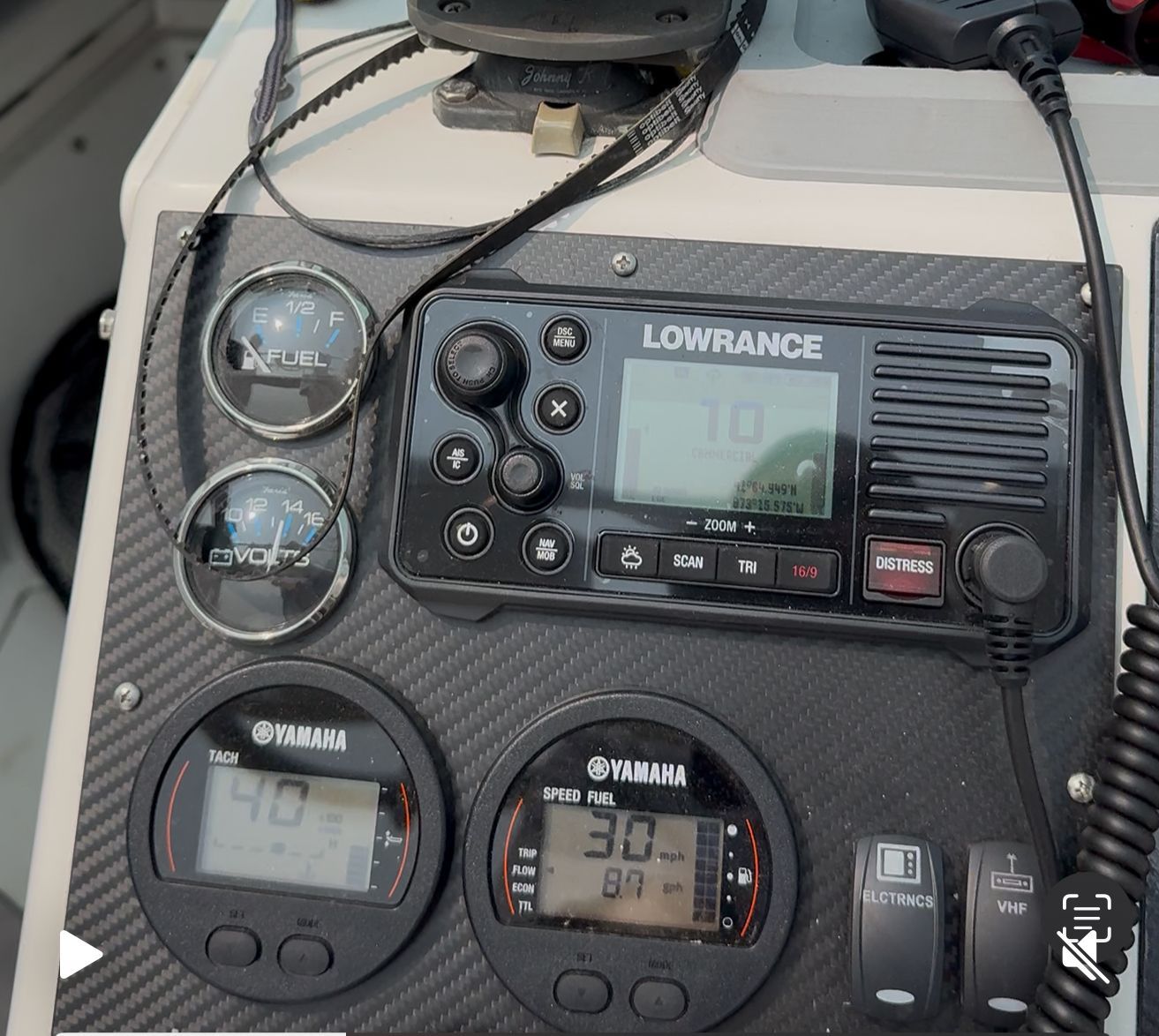 Close-up of a boat dashboard with instruments and a Lowrance device.