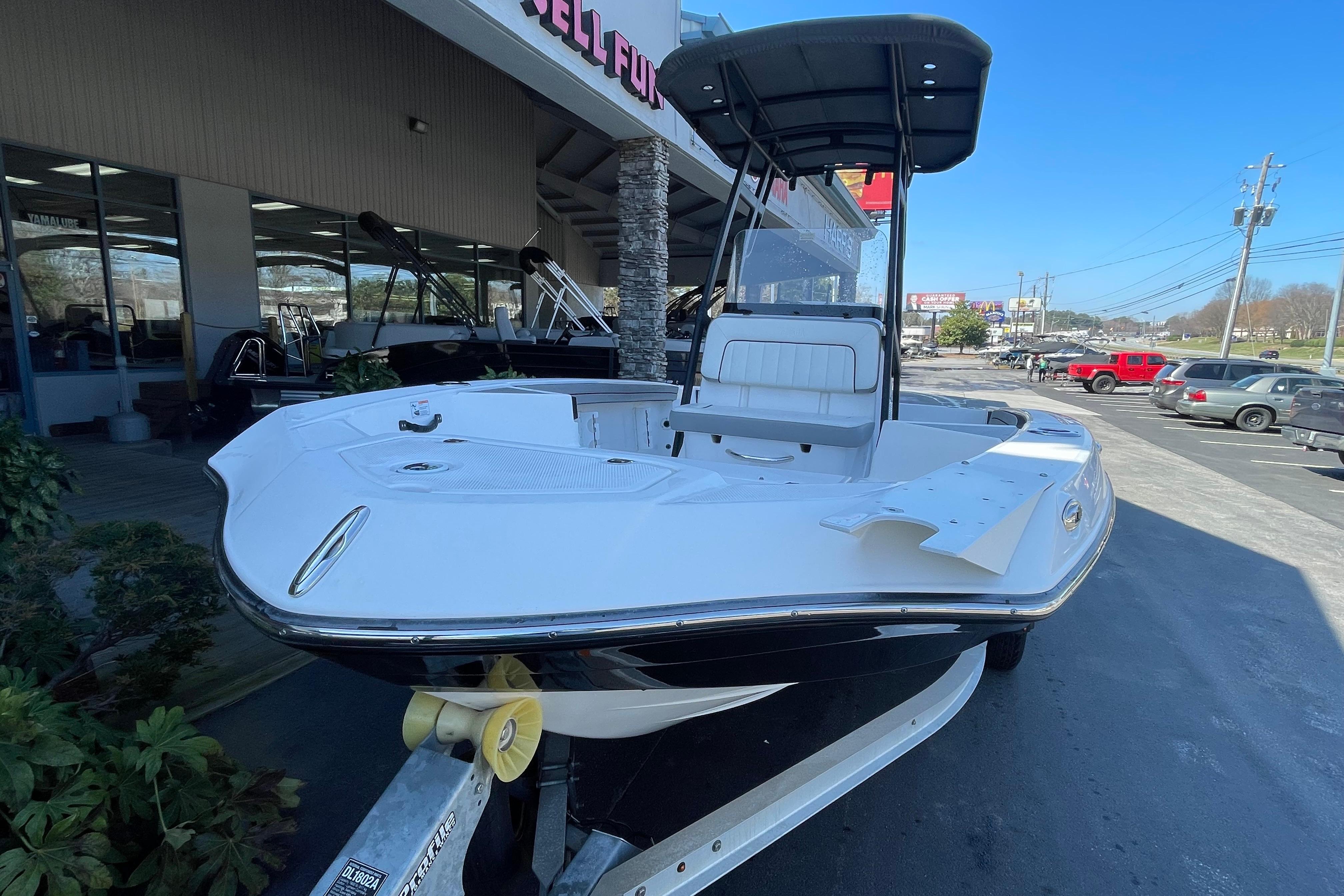 2021 Yamaha Boats 195 FSH Sport displayed outside dealership, showcasing sleek design.