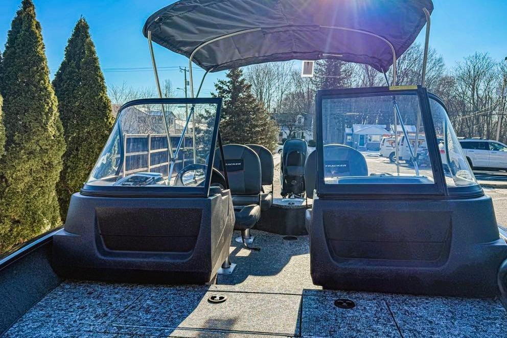 2026 Tracker Targa V-19 WT boat interior with canopy, windshield, and seating under clear blue sky.