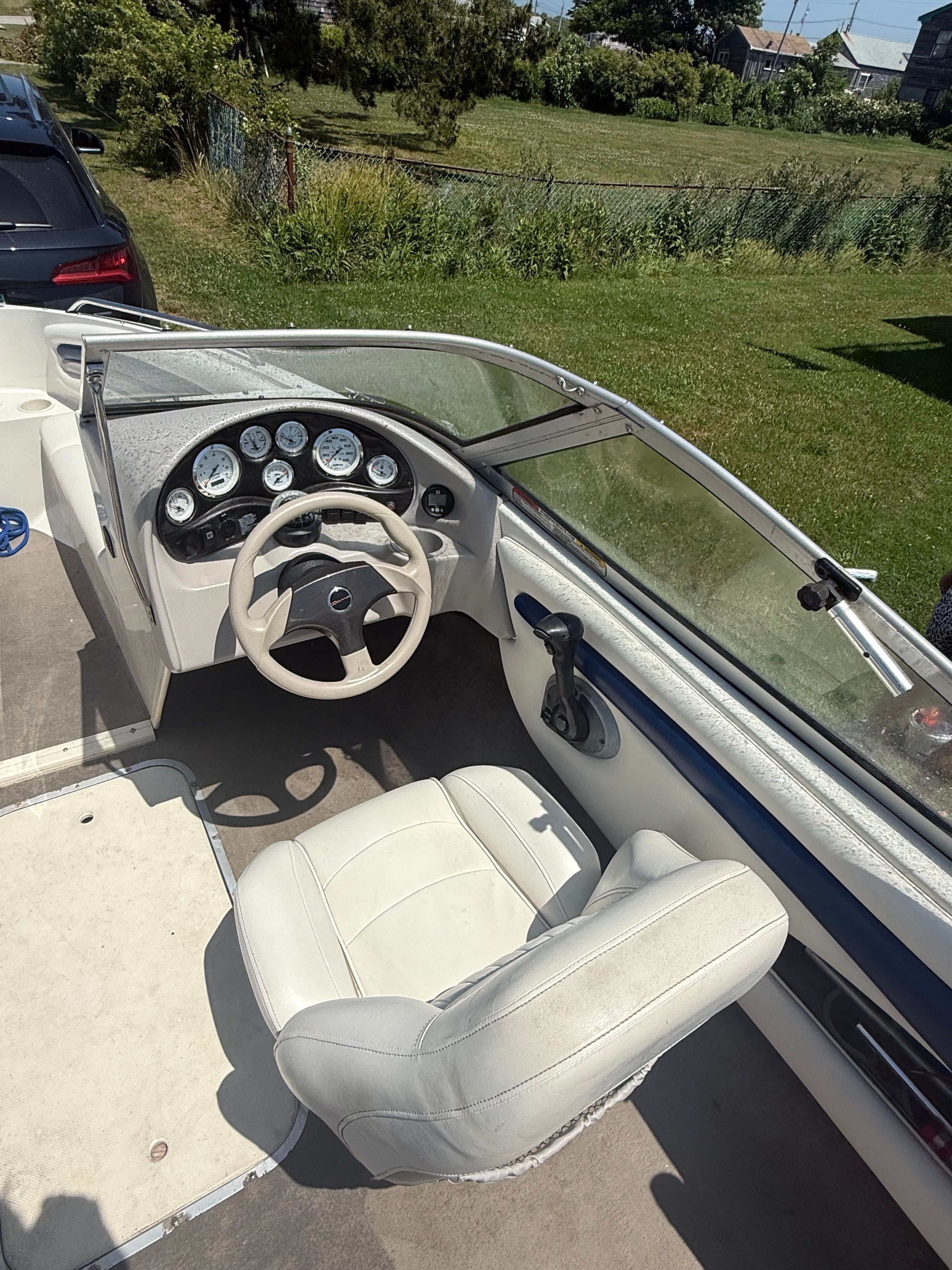 The image shows the cockpit of a 2003 Stingray 180 LS/LX with a white steering wheel and dashboard.