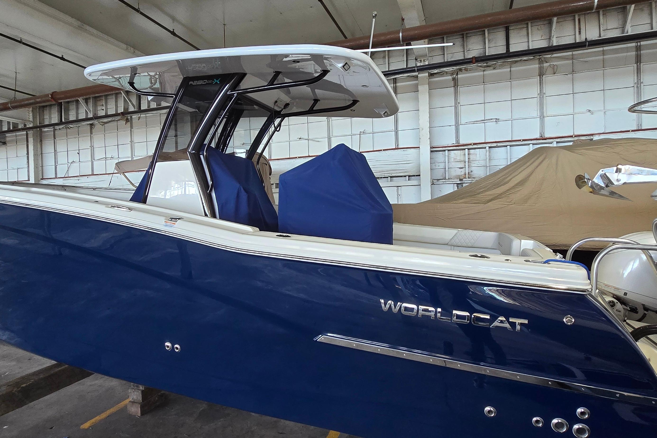 2024 WorldCat 280 CC-X boat in a warehouse, featuring a sleek blue design.