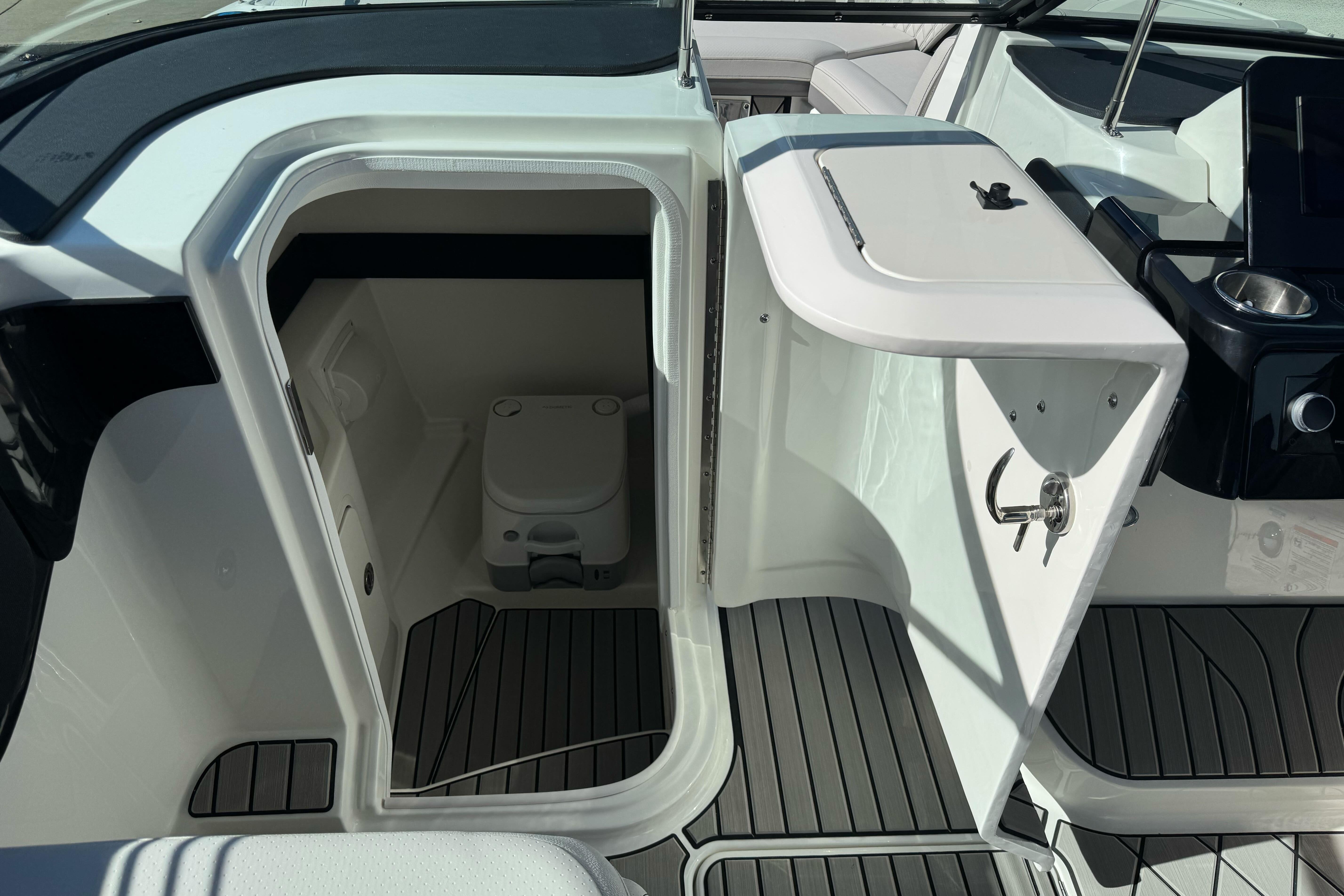 2026 Sea Ray SLX 260 boat interior with compact marine toilet and sleek design.