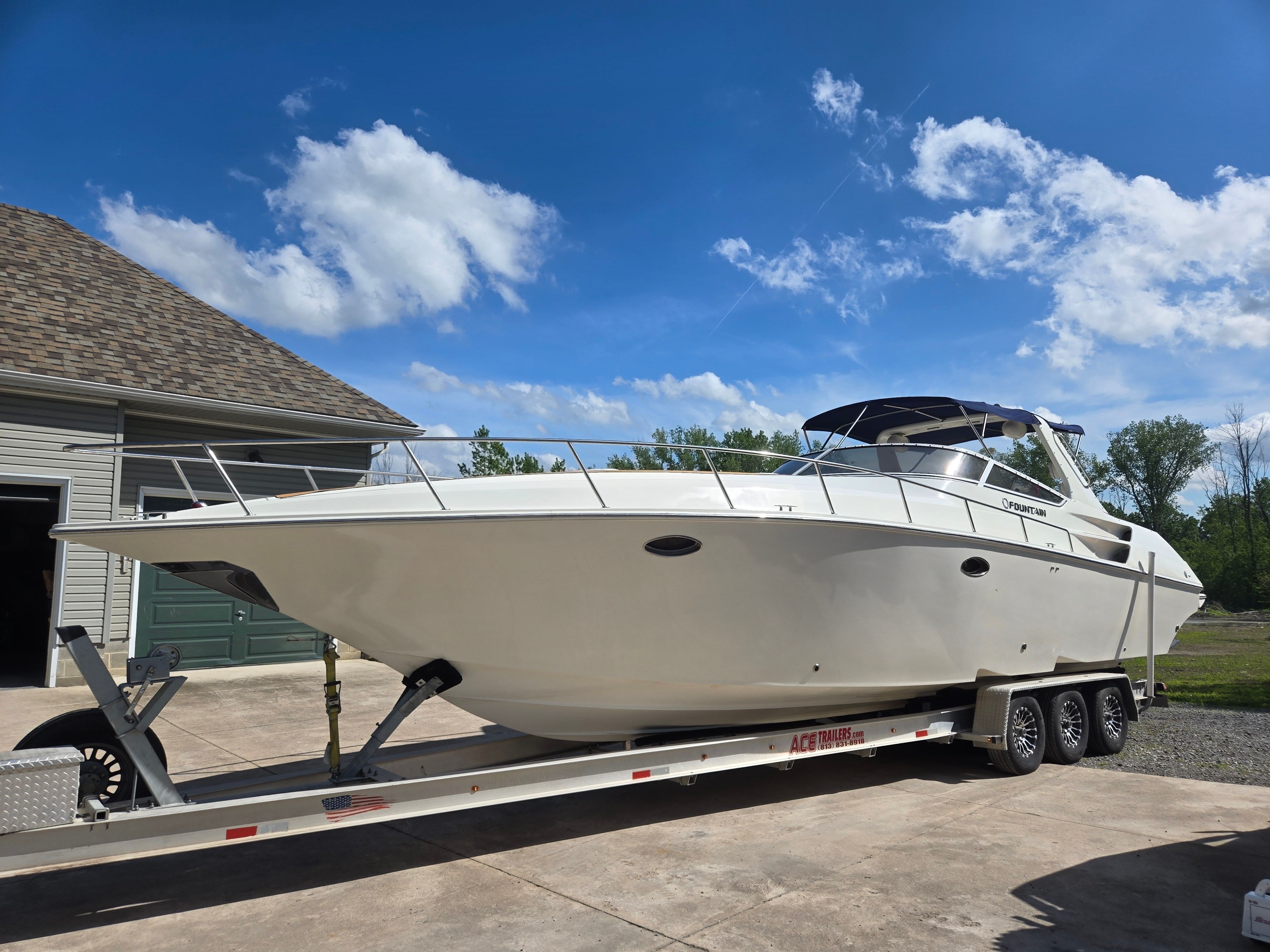 2004 Fountain 38 Express Cruiser on trailer, blue sky.