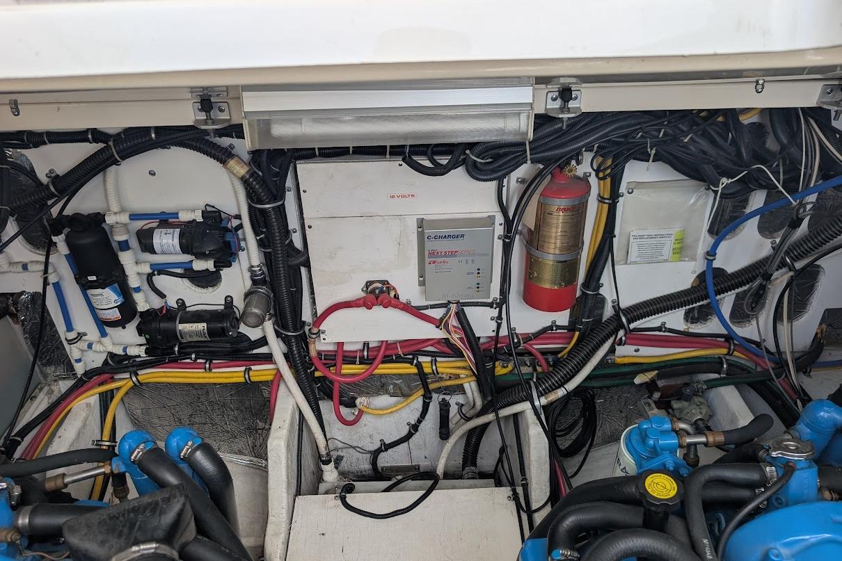 Engine compartment of a 2000 Pursuit 3400 Express boat, showcasing wiring and components.