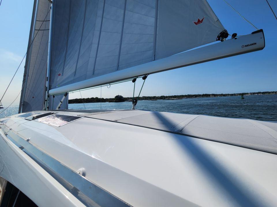 Sailing on a 2025 Moody 48 DS yacht with clear skies and calm waters.