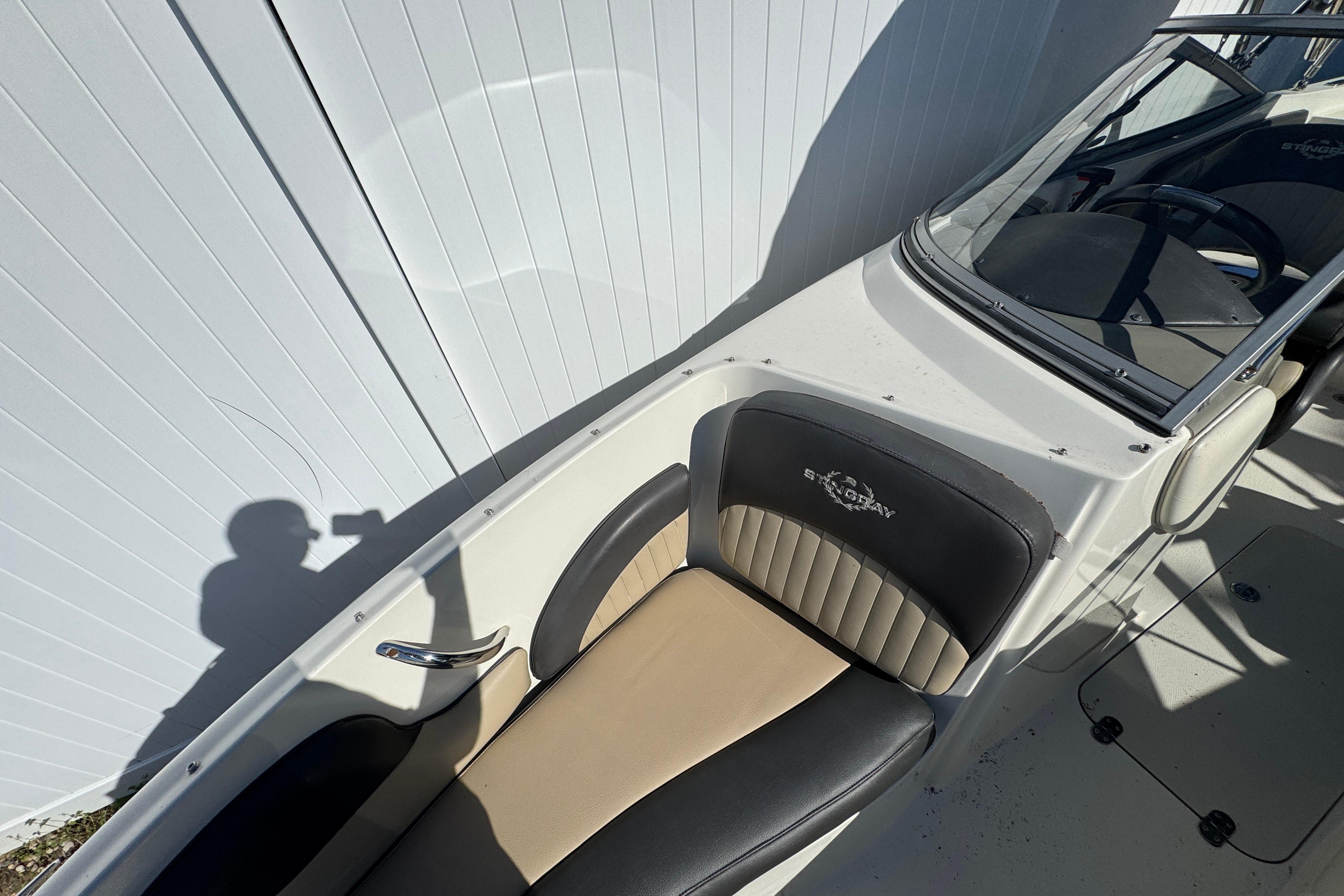 2018 Stingray 204 LR boat interior with black and beige seating, steering wheel visible.