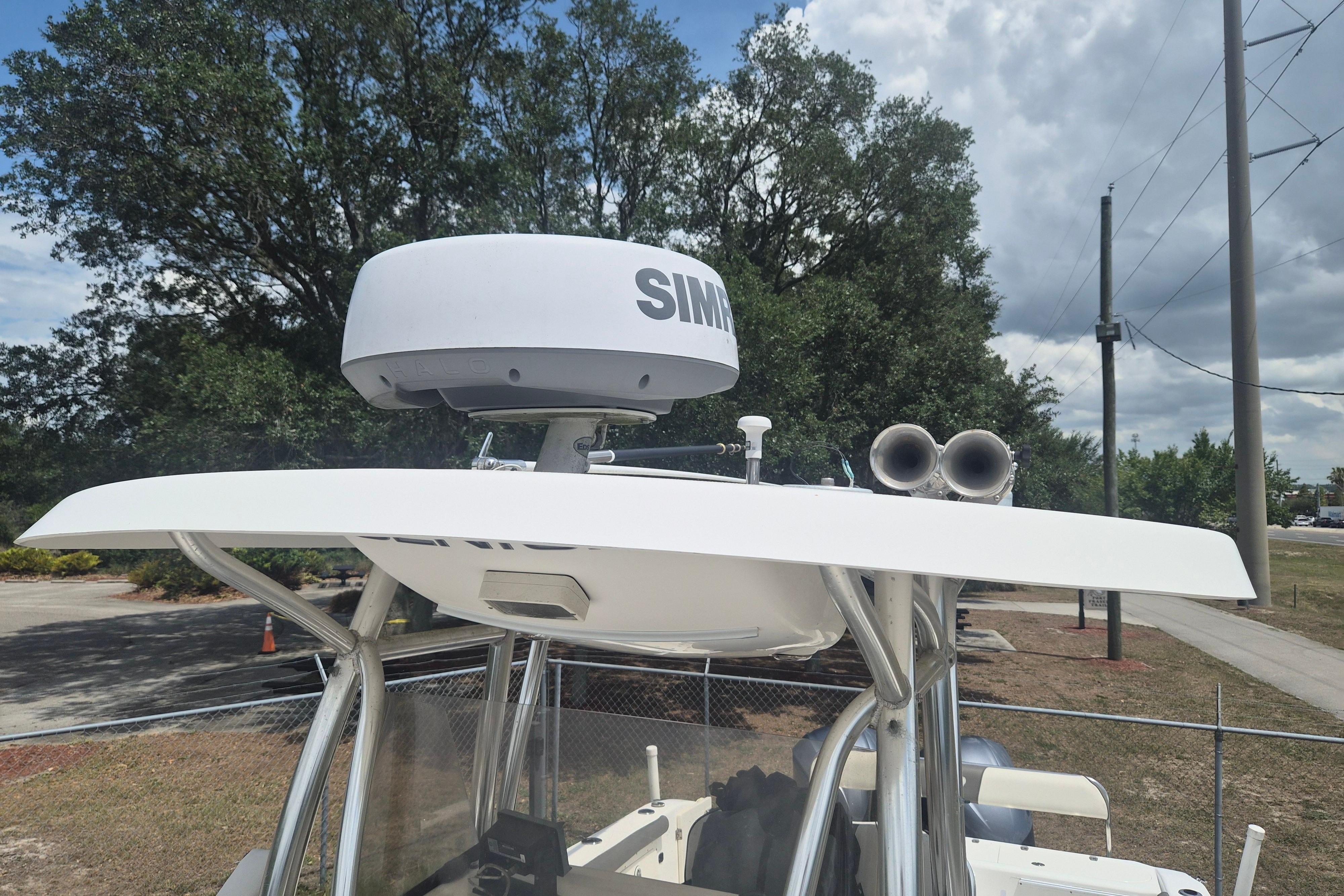 2006 Century 2900 Center Console boat with radar and speakers, parked outdoors.