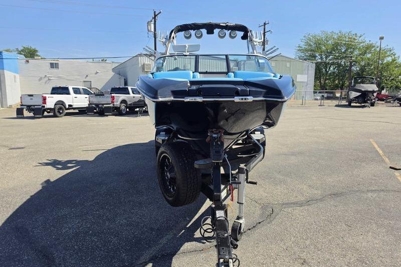 2017 MasterCraft X23 boat on trailer in parking lot, front view.