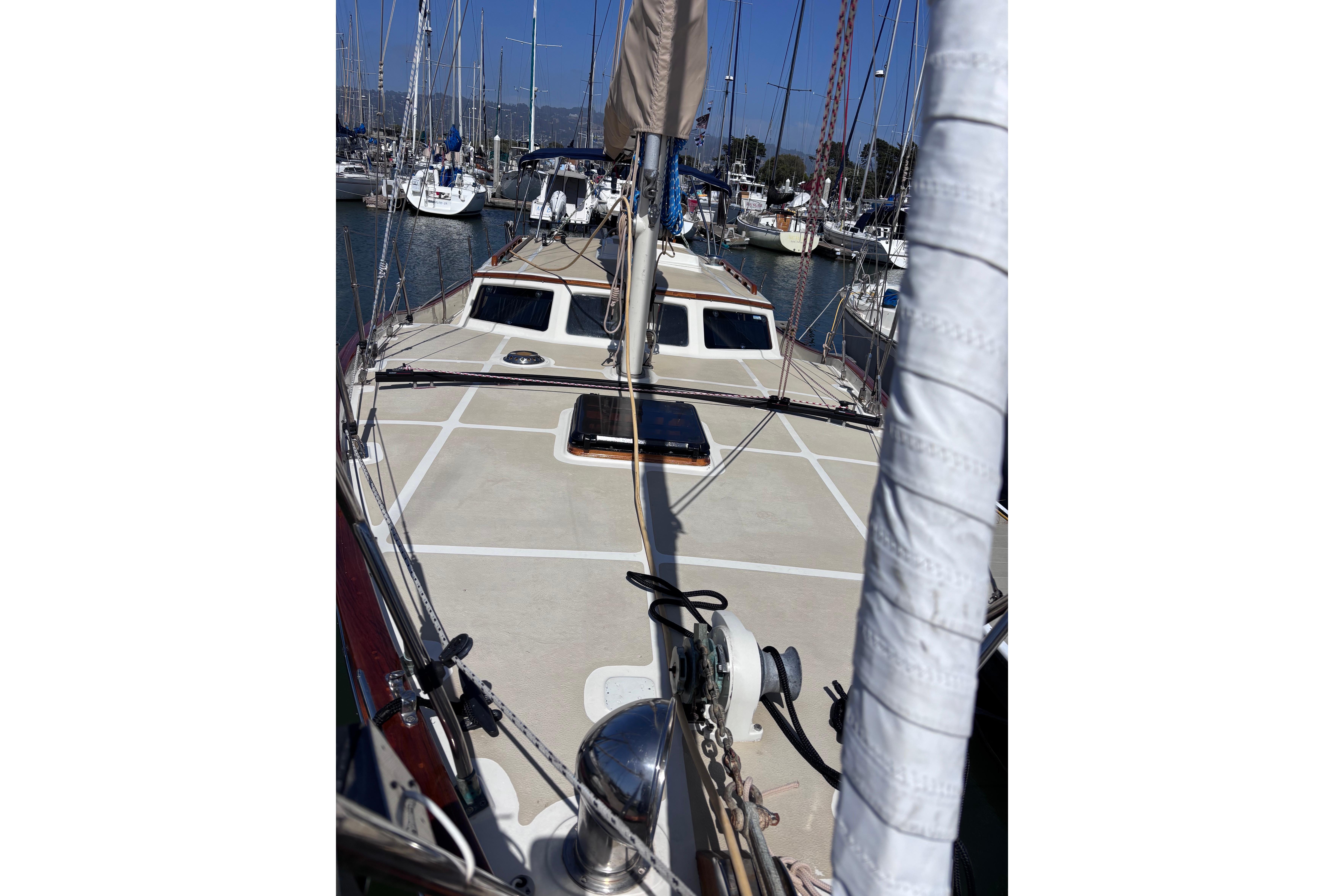 1978 Swift 33 sailboat deck view in marina, surrounded by other boats.