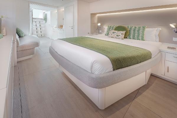 Luxurious bedroom interior of 2025 Lagoon SIXTY 5 yacht with modern design and green accents.
