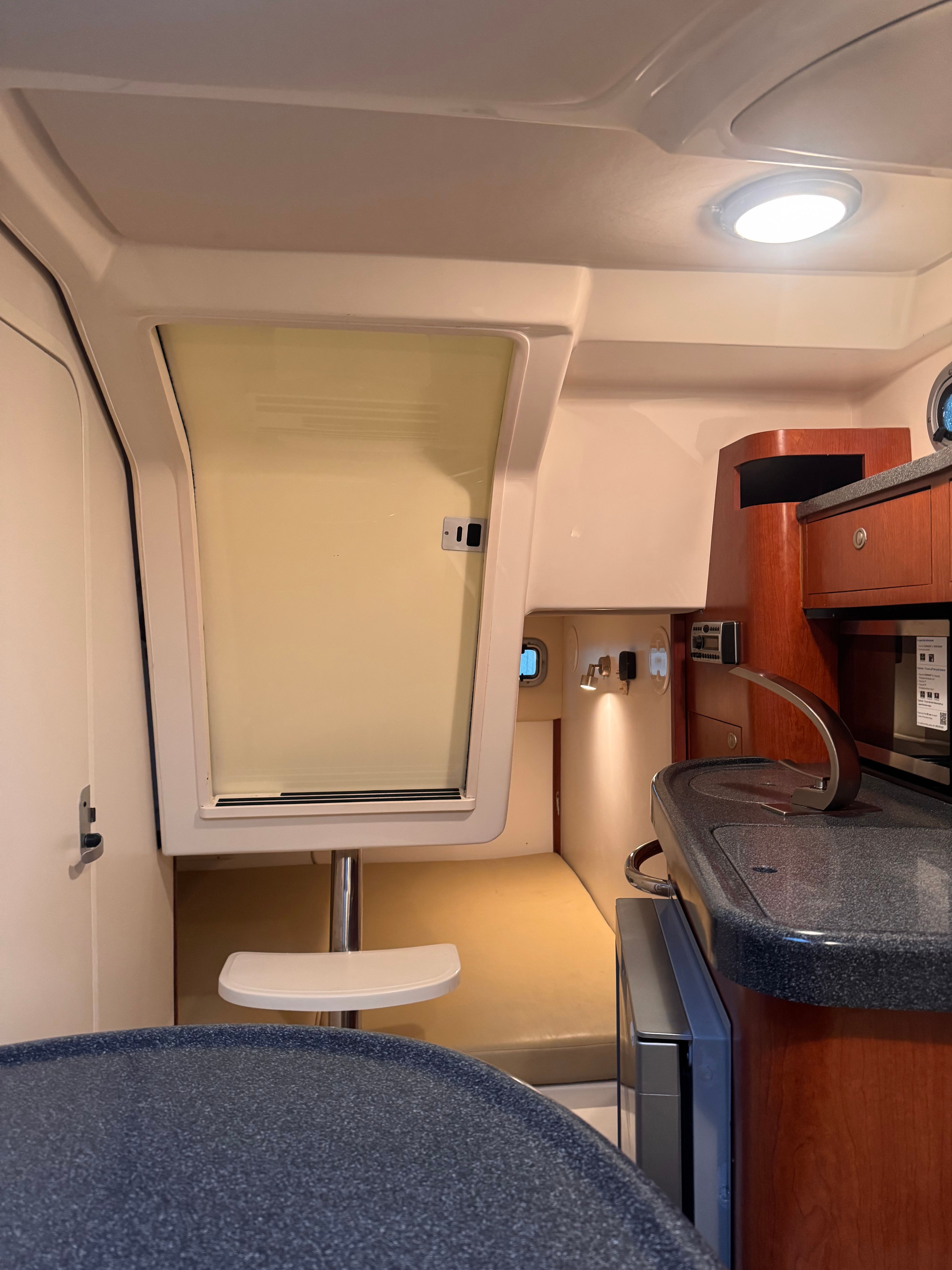 Interior of the 2006 Boston Whaler 305 Conquest with kitchenette and seating area.
