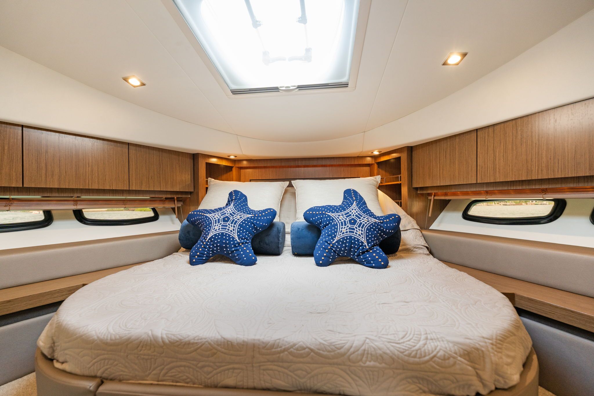 Interior of the 2017 Sea Ray Sundancer 510 with a cozy bed and star-shaped pillows.