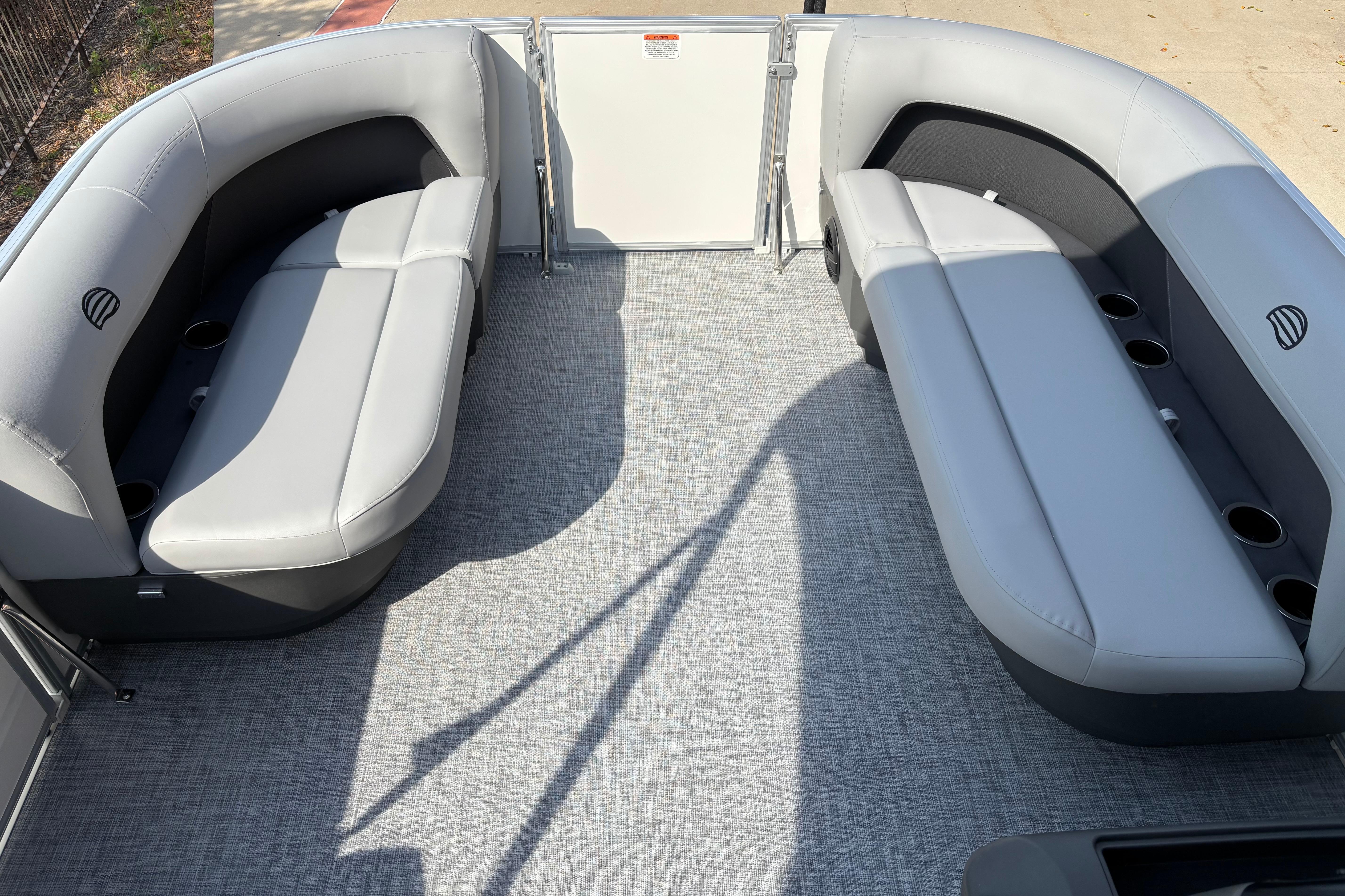 2026 Sun Tracker Party Barge 16 DLX interior with gray seating and cup holders.