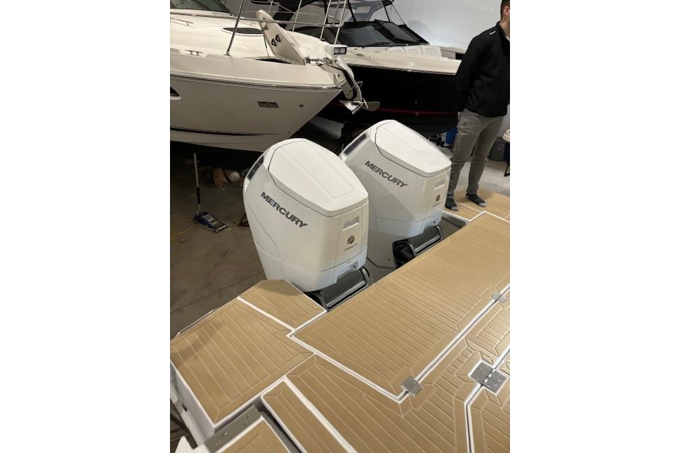 2024 Cruisers Yachts 42 GLS OB with dual Mercury outboard engines in a showroom.
