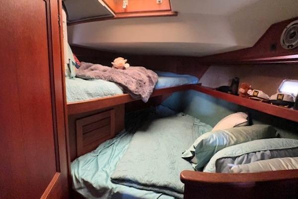 Cozy cabin interior of 1980 Viking 43 Convertible yacht with bunk beds and wooden finish.