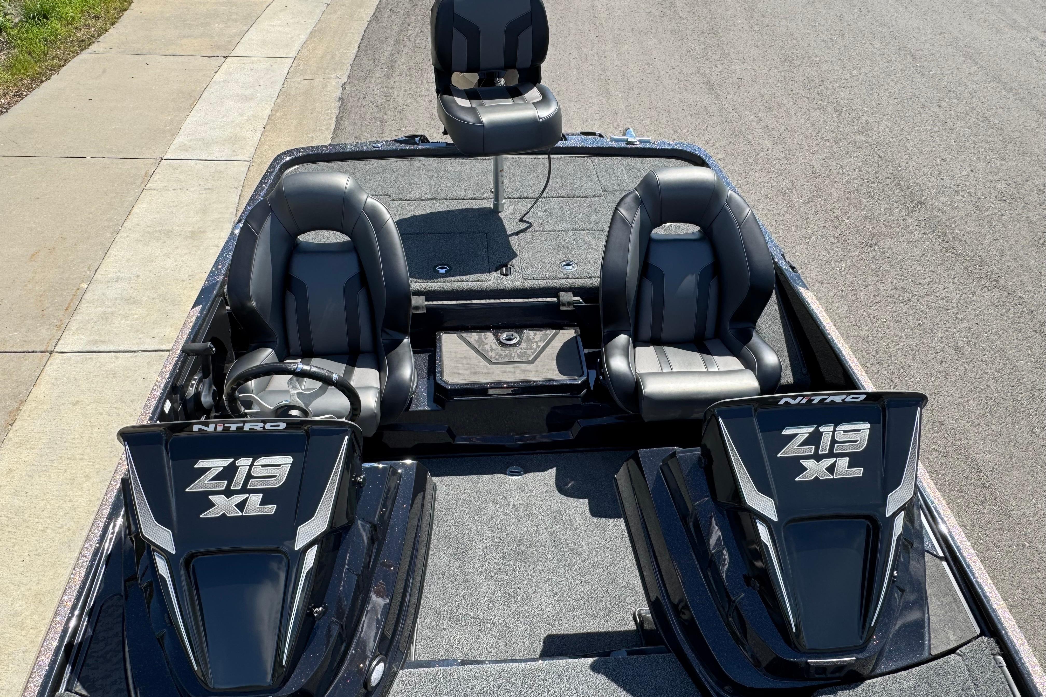 2026 Nitro Z19 XL boat interior with dual seats and steering wheel, parked on pavement.