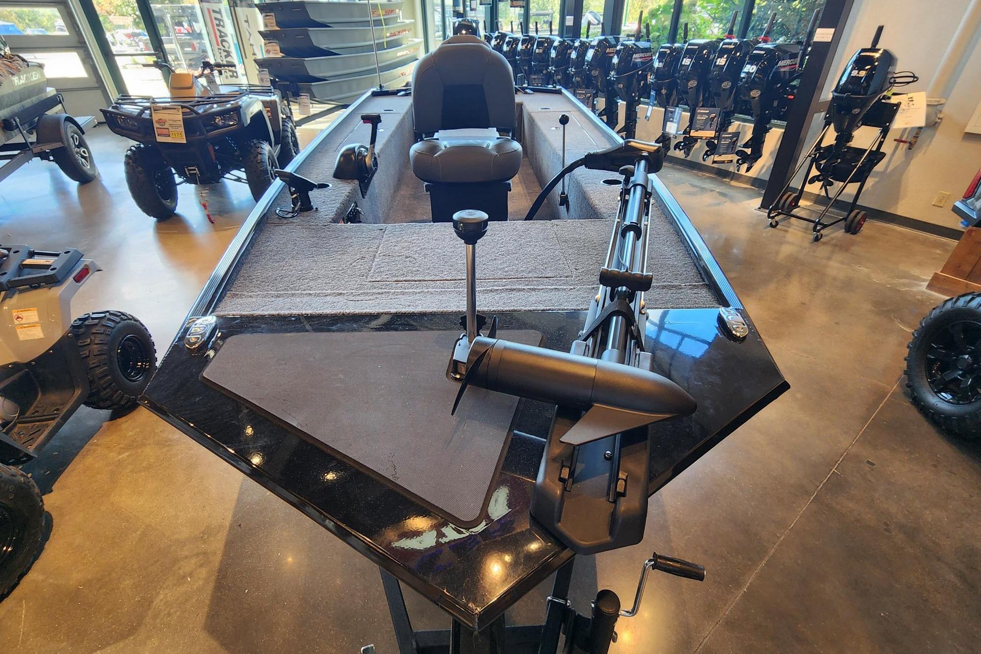 2026 Tracker Panfish 17 boat displayed in showroom with fishing equipment.