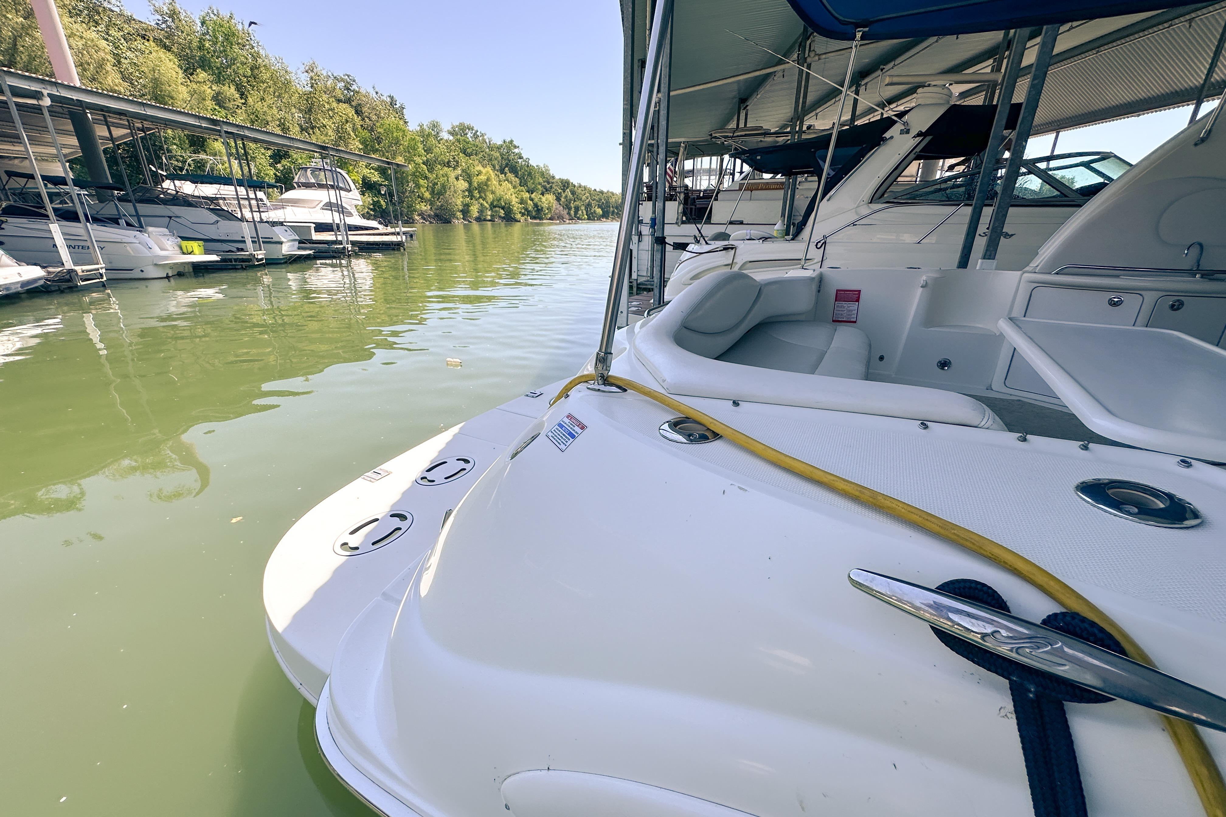 2001 Sea Ray 410 Sundancer docked at a marina with lush greenery.