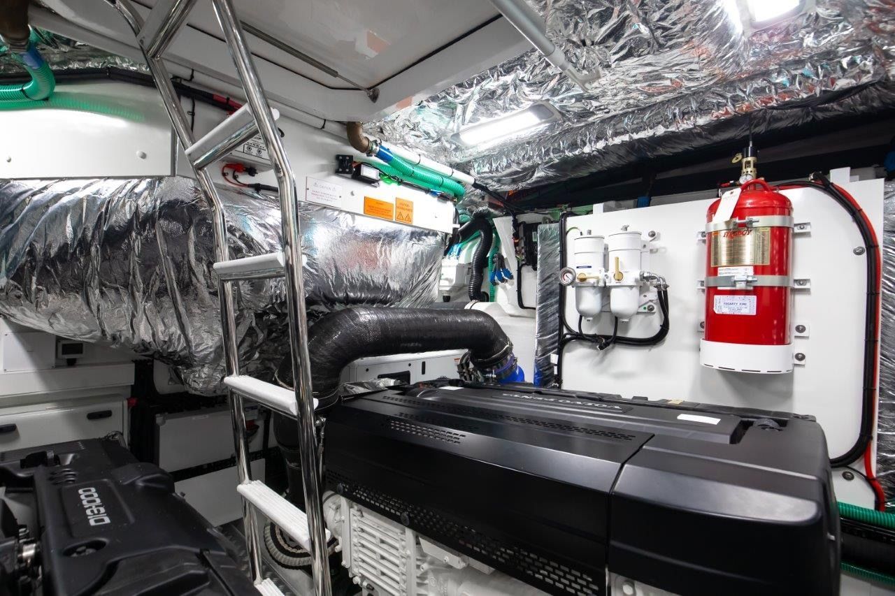 Engine room of the 2025 Princess V55 yacht, featuring modern equipment and a fire extinguisher.