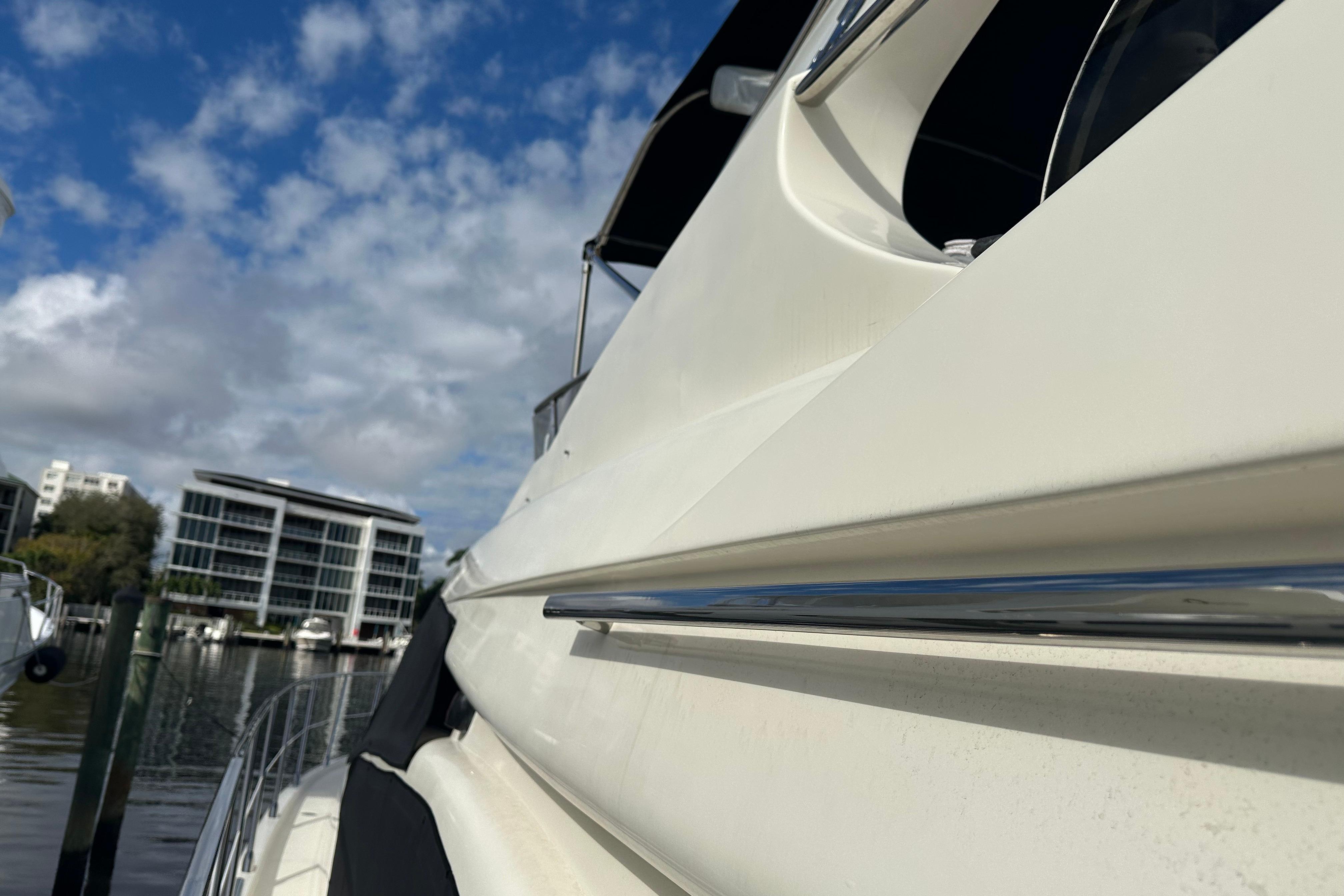 2004 Azimut 55E yacht docked, showcasing sleek design under a partly cloudy sky.