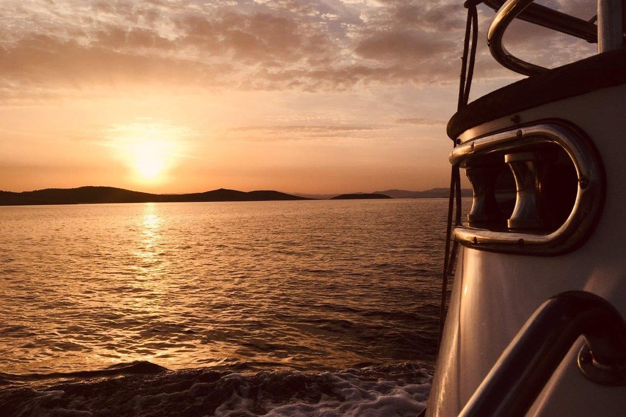 Sunset view from Elegance 64 yacht, 2007 model, on serene ocean waters.