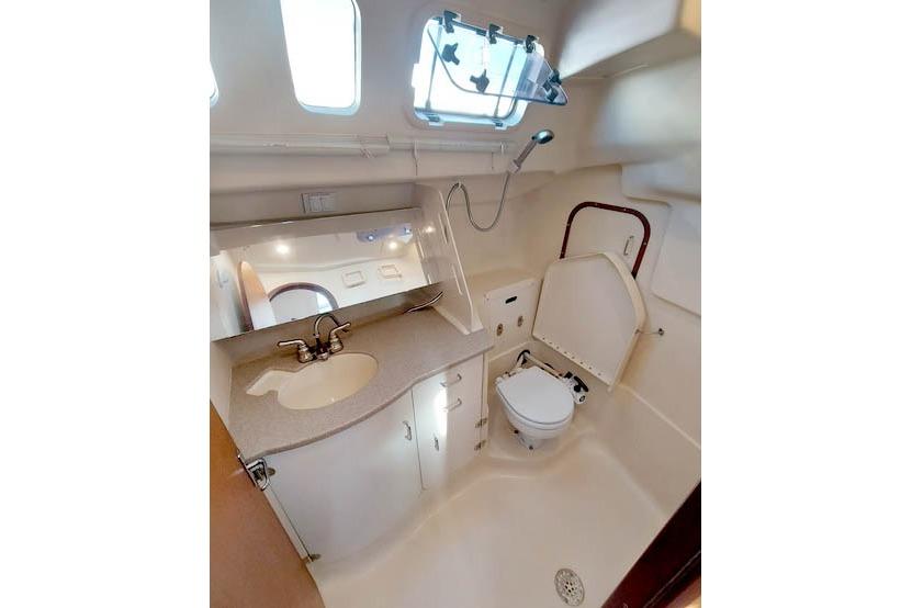 Interior of 1998 Hunter 340 sailboat bathroom with sink, toilet, and shower.