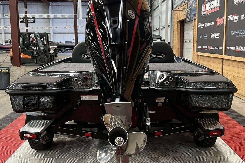2026 Triton 20XP Patriot boat in showroom, rear view with powerful engine.