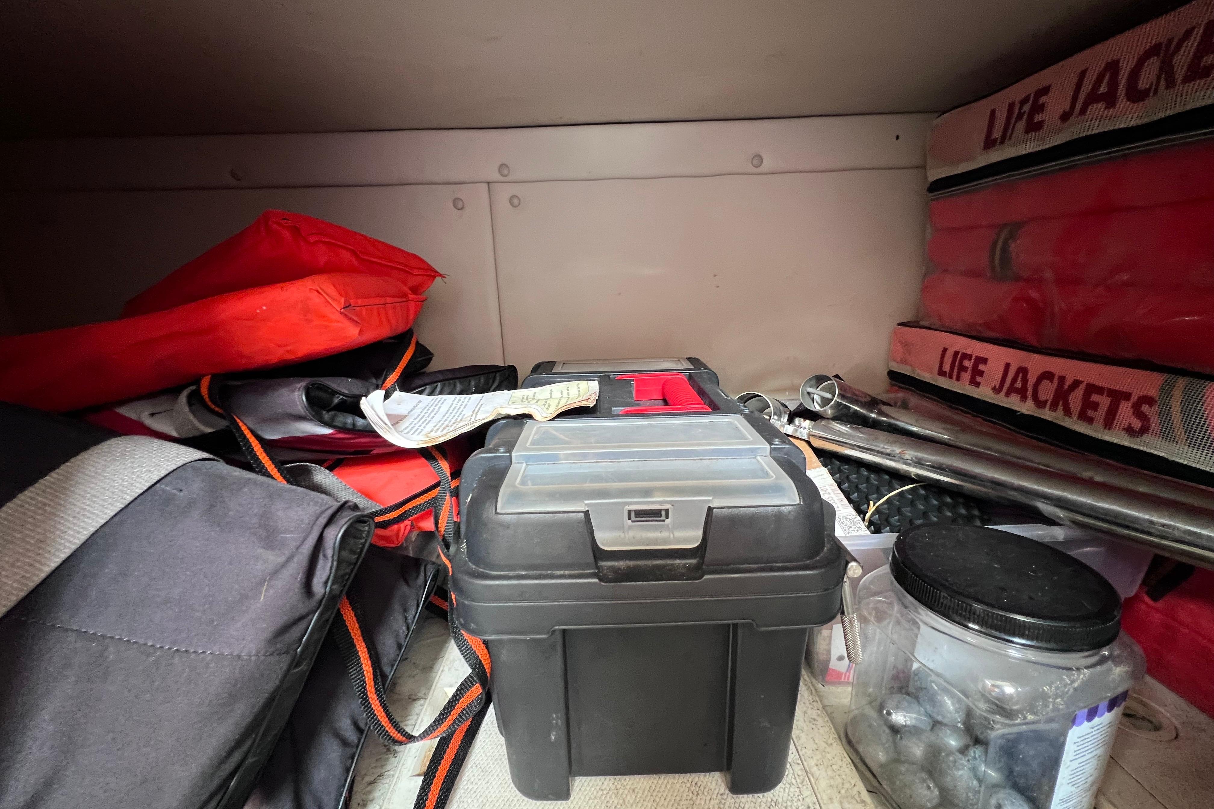 Storage compartment in a 2005 Pursuit 3070 Offshore boat with life jackets and gear.