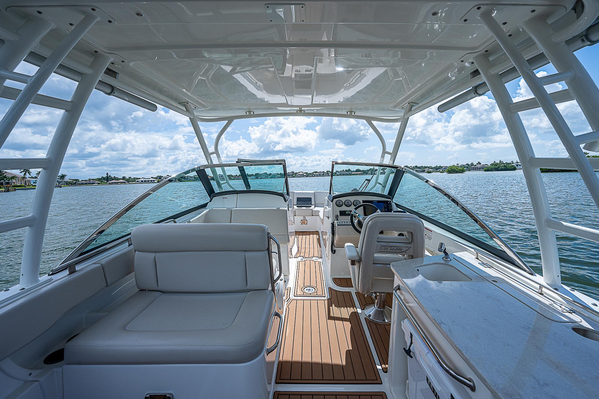 2018 Boston Whaler 270 Vantage boat interior with seating and helm, on a sunny day.